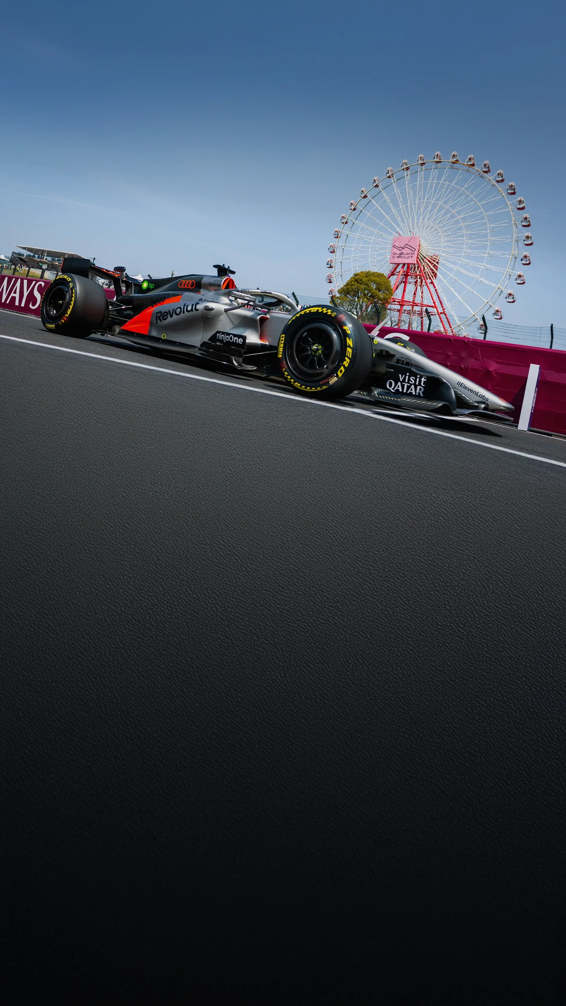Gabriel Bortoleto in the Audi Revolut F1® Team car passes the Suzuka Circuit ferris wheel during track action.