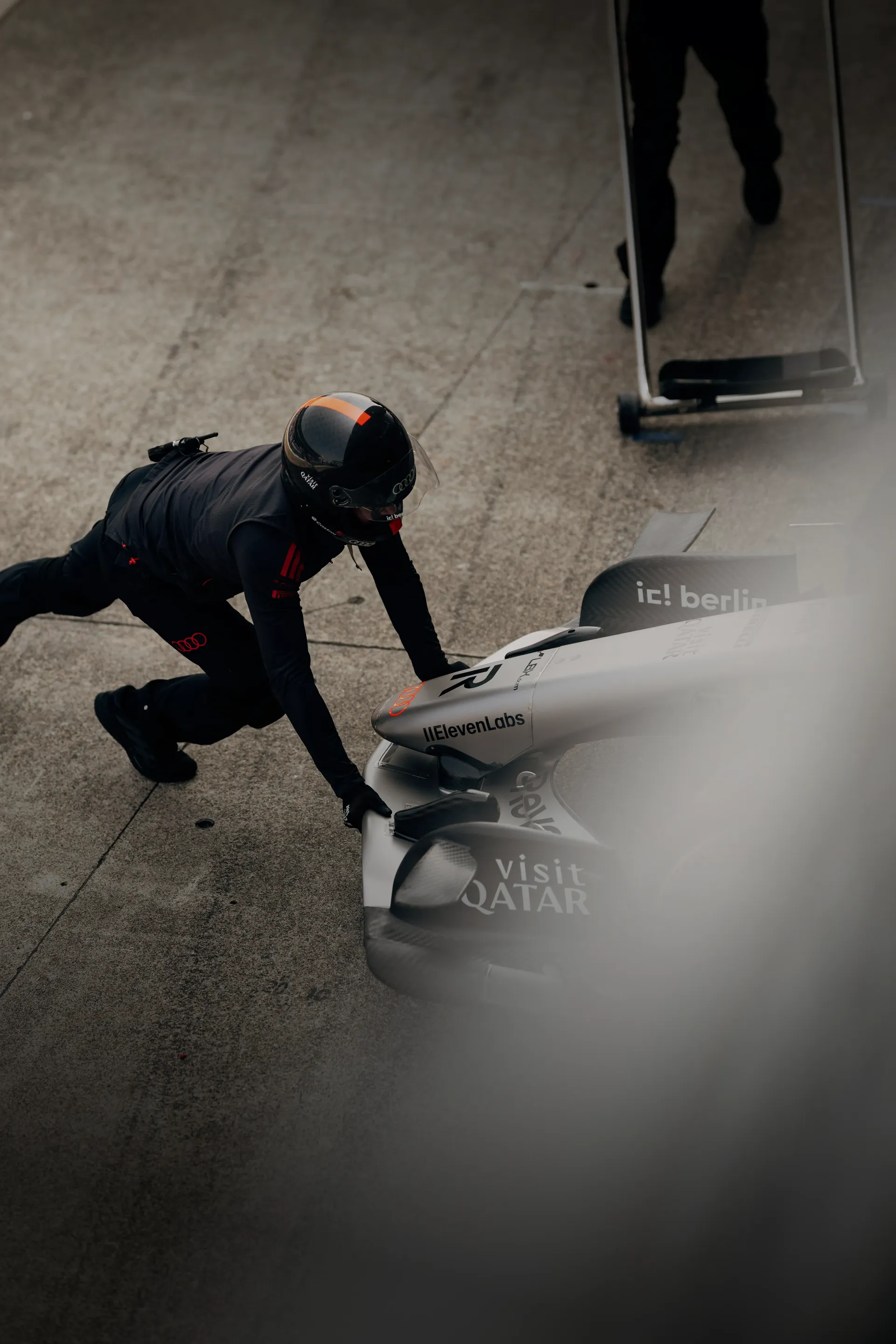 Crew member of the Audi Revolut F1® Team pushing the car back into the garage
