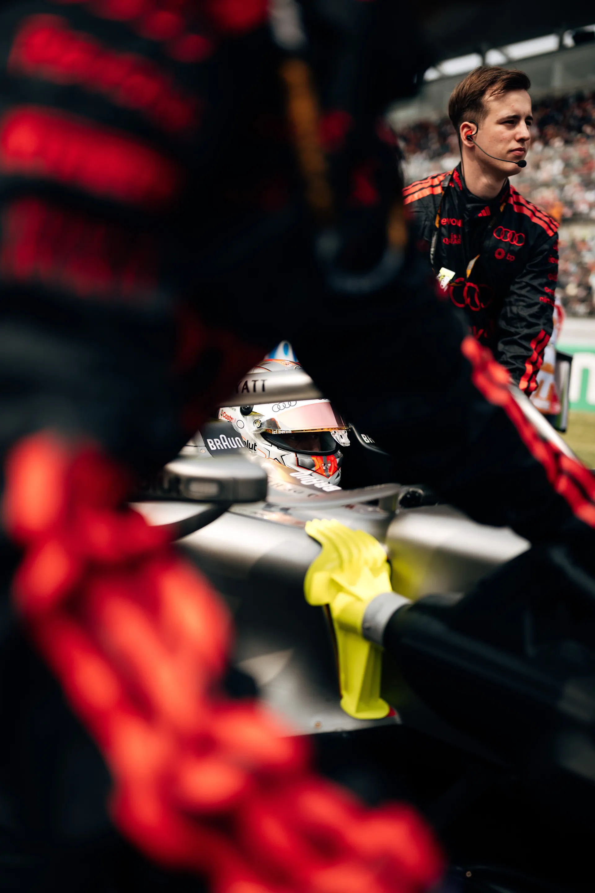 Audi Revolut F1® Team crew members surround Nico Hulkenberg in the cockpit as the car is prepared on the grid.
