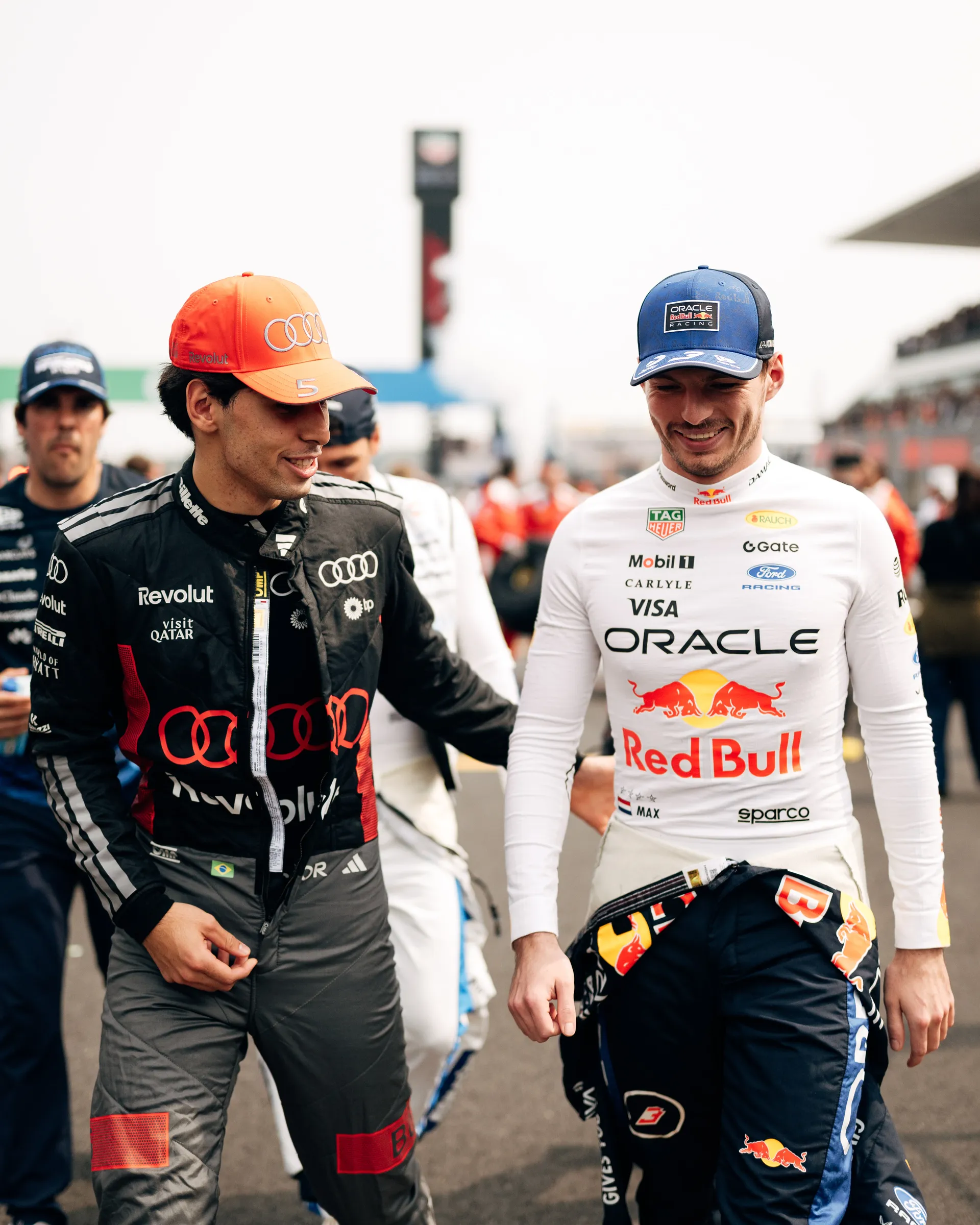 Gabriel Bortoleto walks on the grid beside Max Verstappen during the pre race buildup.