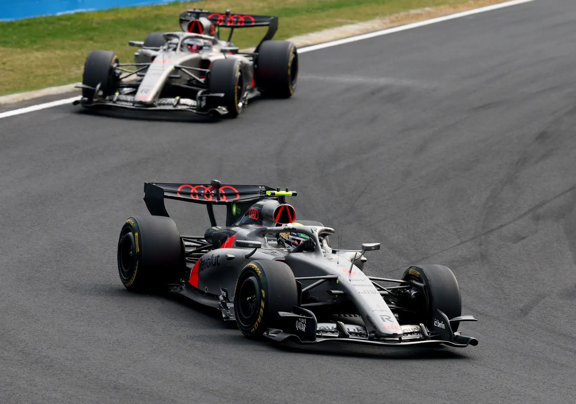 Two Audi Revolut F1® Team cars drive through a Suzuka corner during the Japanese Grand Prix.