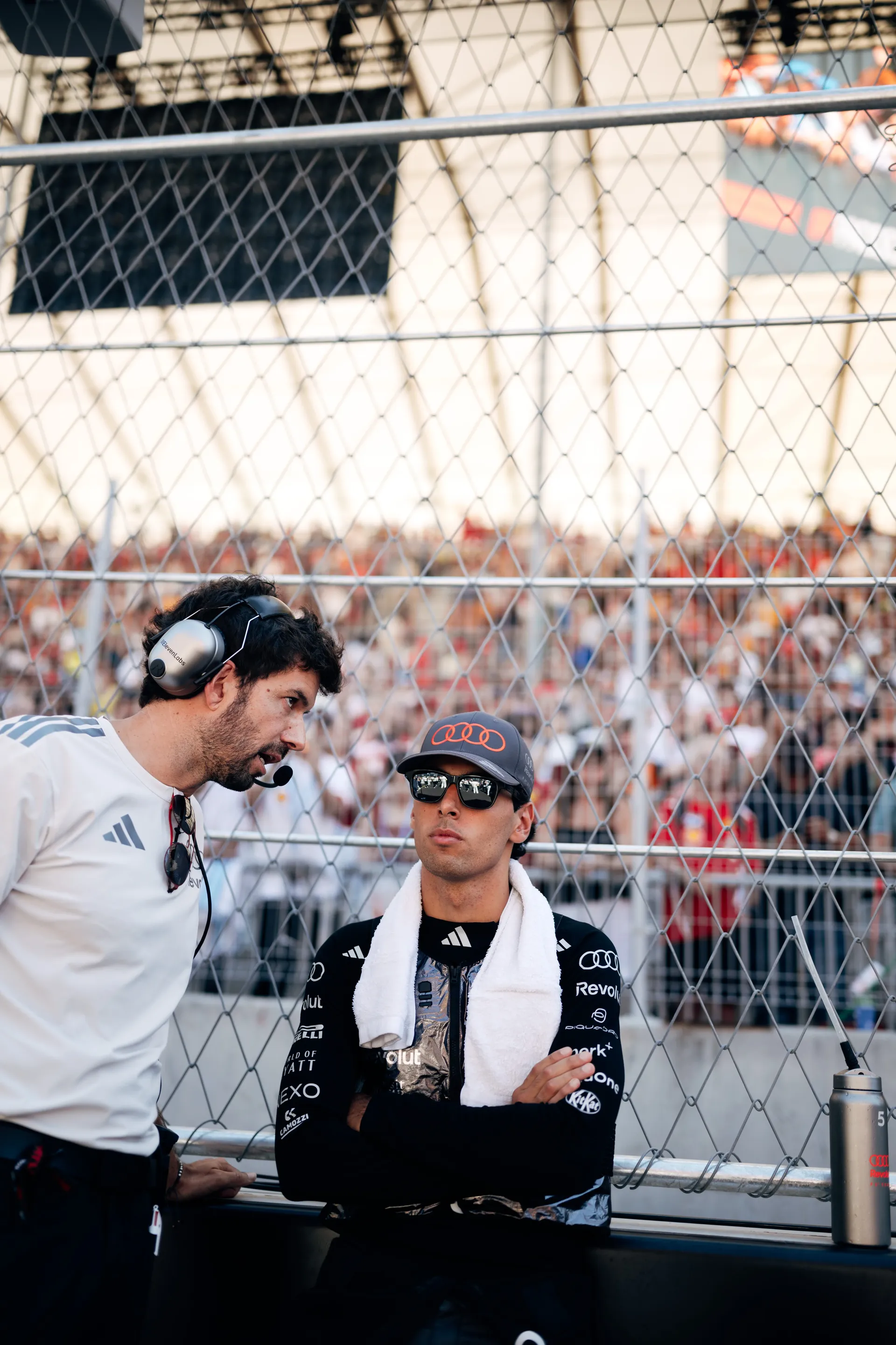 Gabriel Bortoleto of the Audi Revolut F1® Team listening to an engineer in front of a full grandstand in Madrid