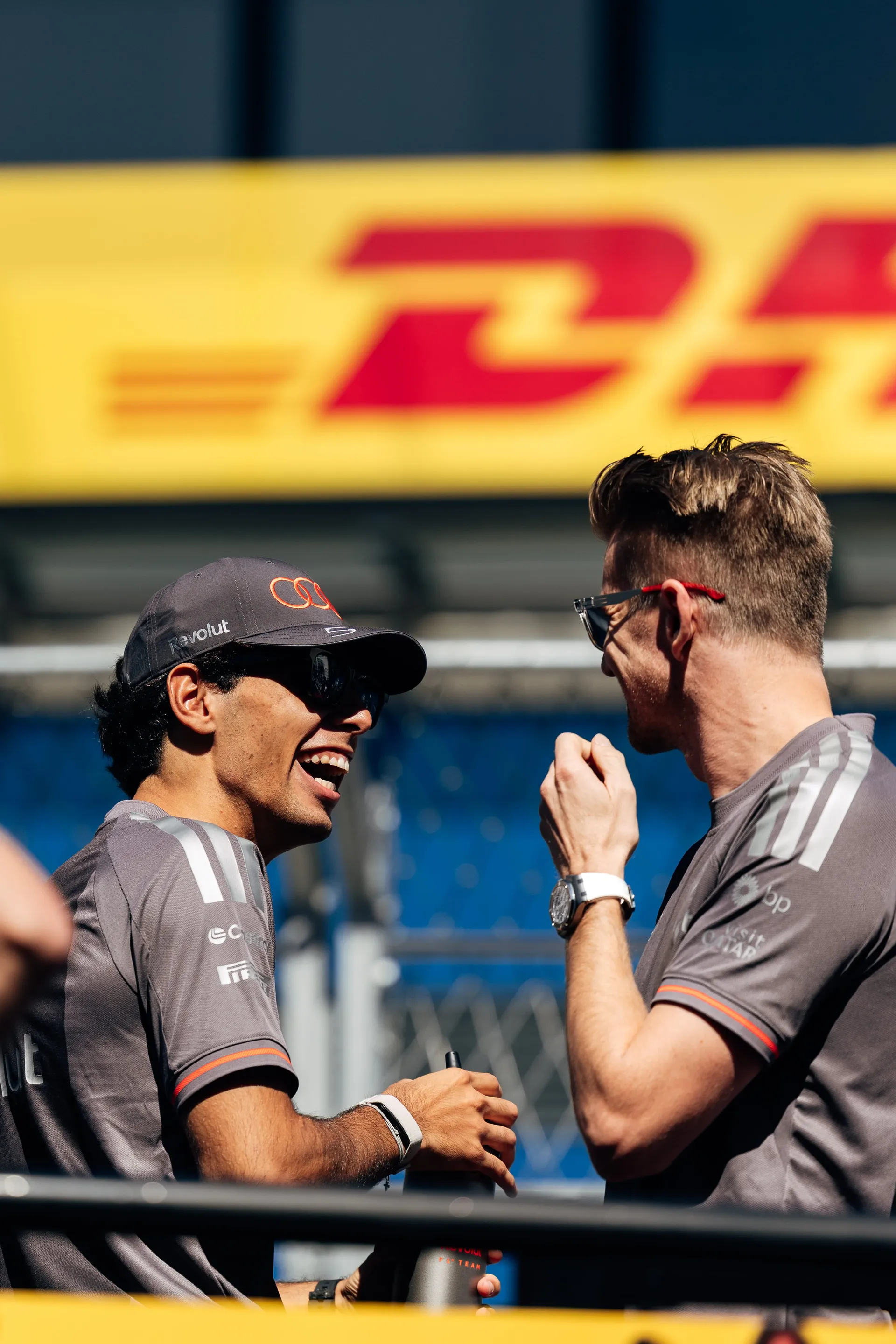 Gabriel Bortoleto and Nico Hulkenberg of the Audi Revolut F1® Team talking in front of a DHL banner in Madrid