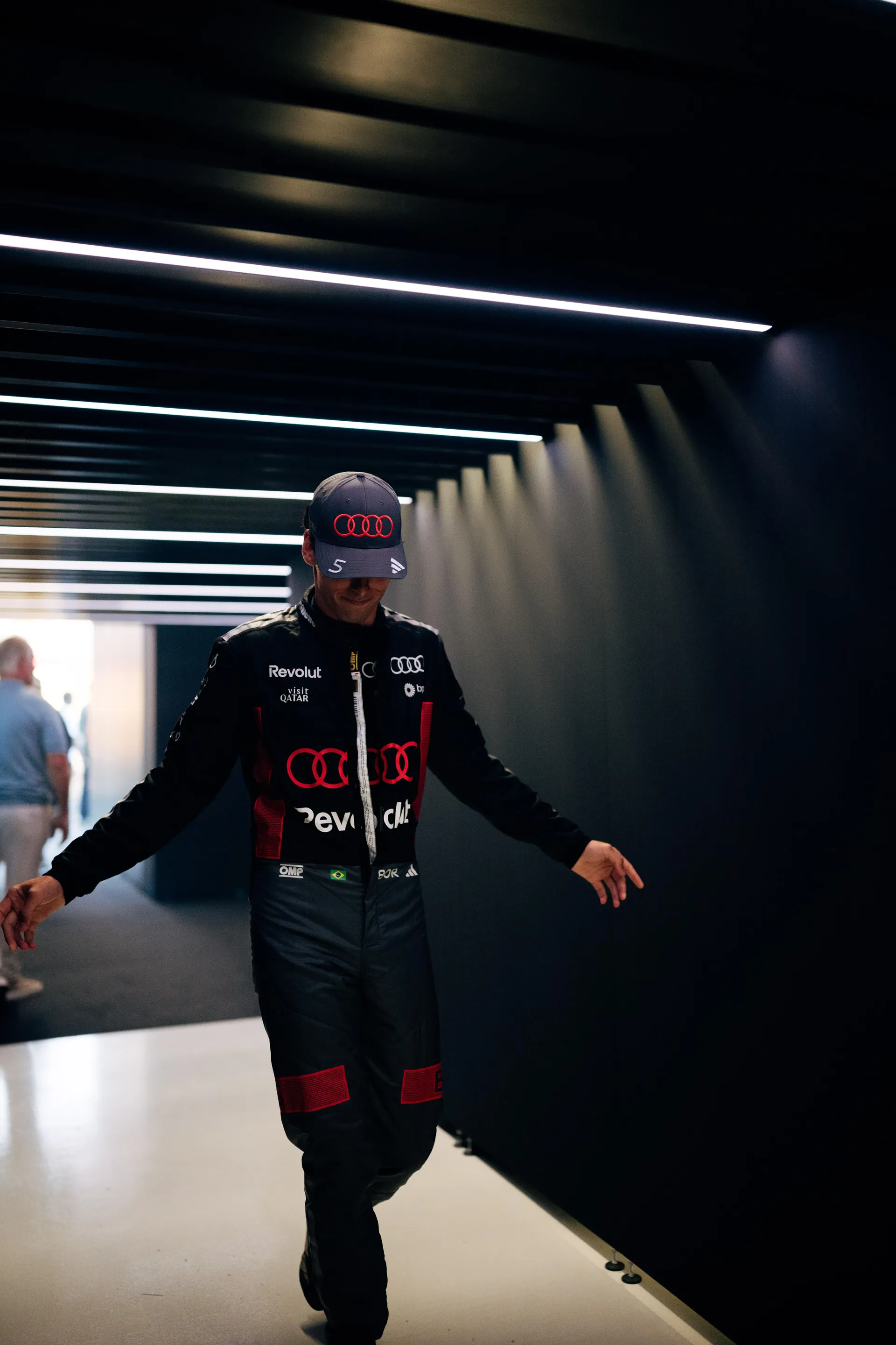 Gabriel Bortoleto of the Audi Revolut F1® Team walking through the paddock corridor in his race suit in Madrid