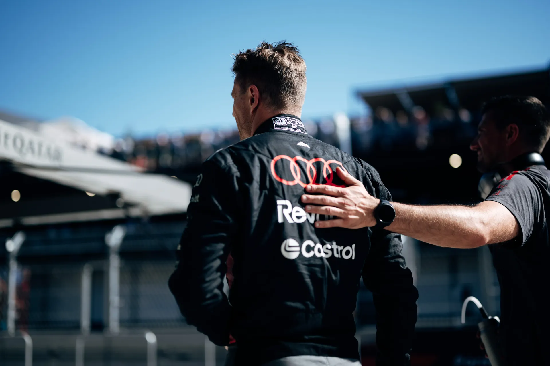 An Audi Revolut F1® Team member congratulating Nico Hulkenberg with a hand on his shoulder in Madrid