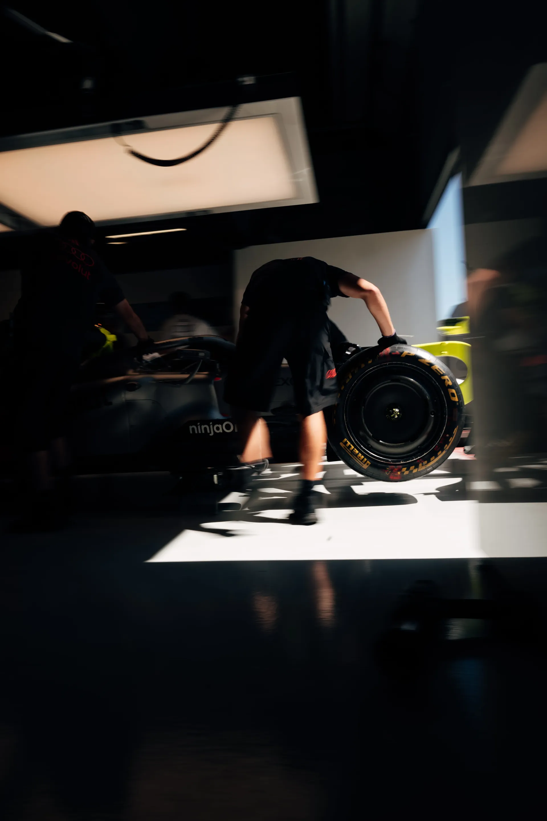 Audi Revolut F1® Team mechanic carrying a Pirelli tyre through the garage in Madrid