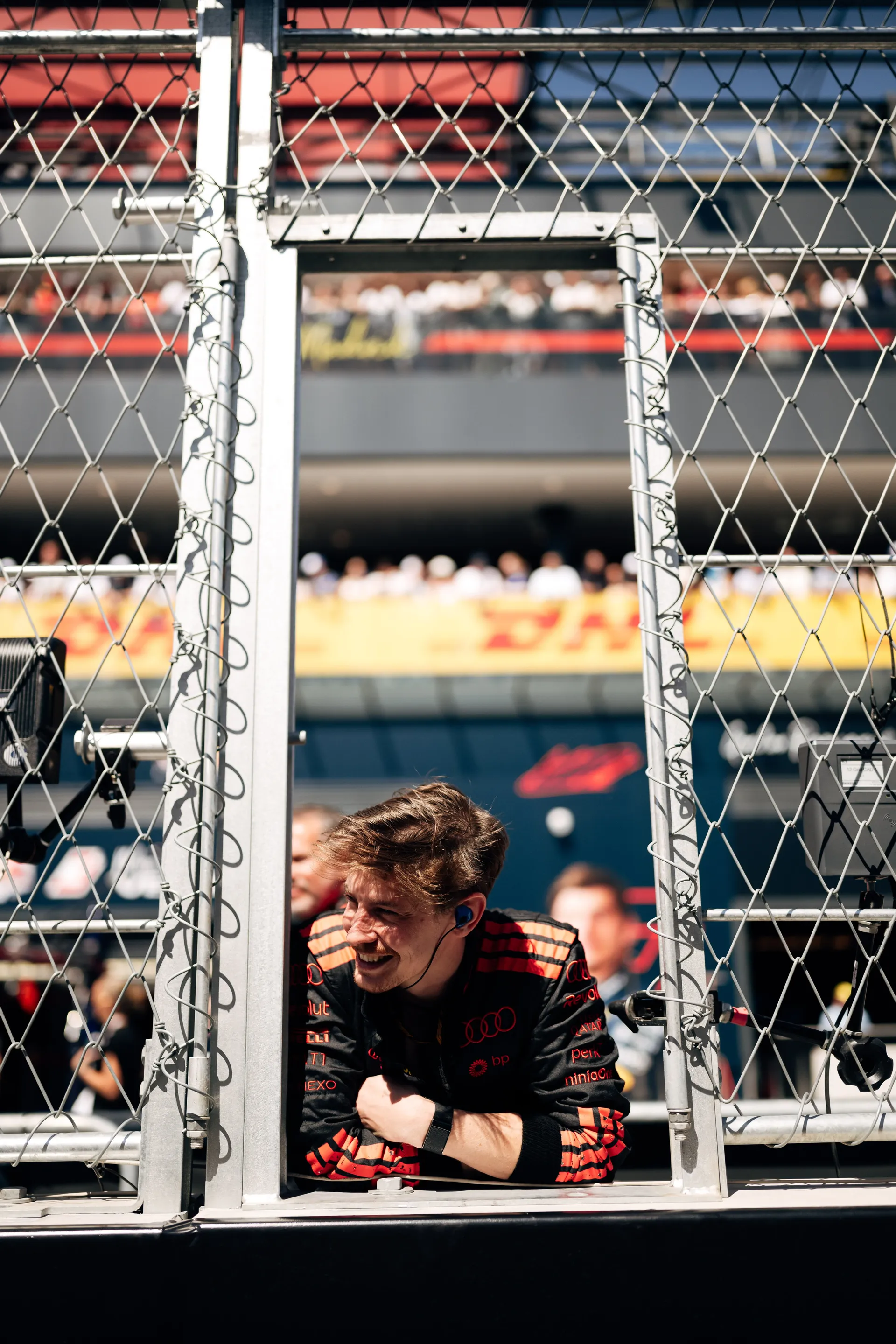 Team member of the Audi Revolut F1® Team leaning through an opening in the trackside fence in Madrid