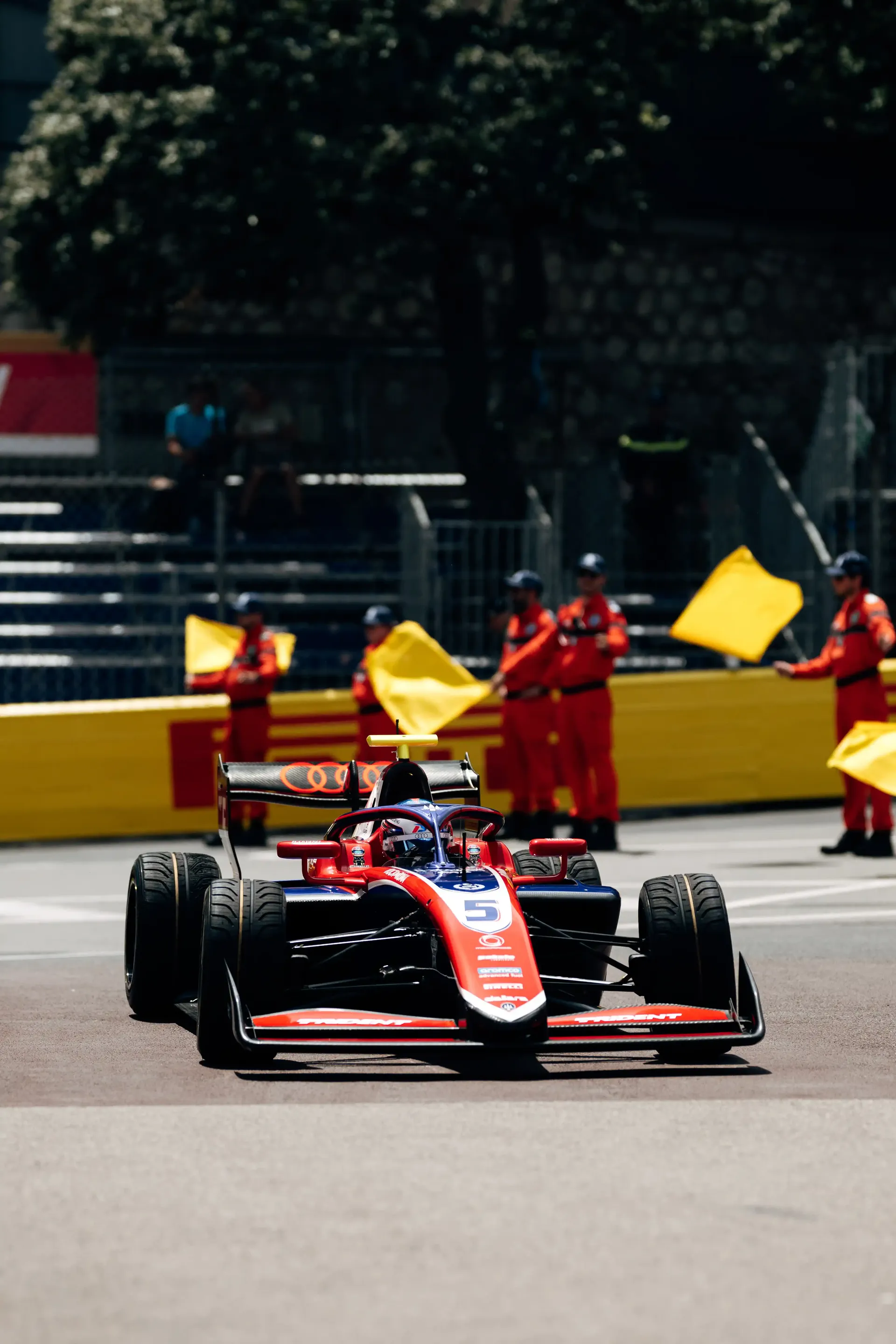 Freddie Slater drives his FIA Formula 3 car through a section of the Monaco street circuit during a practice session, with marshals and safety barriers visible in the background.