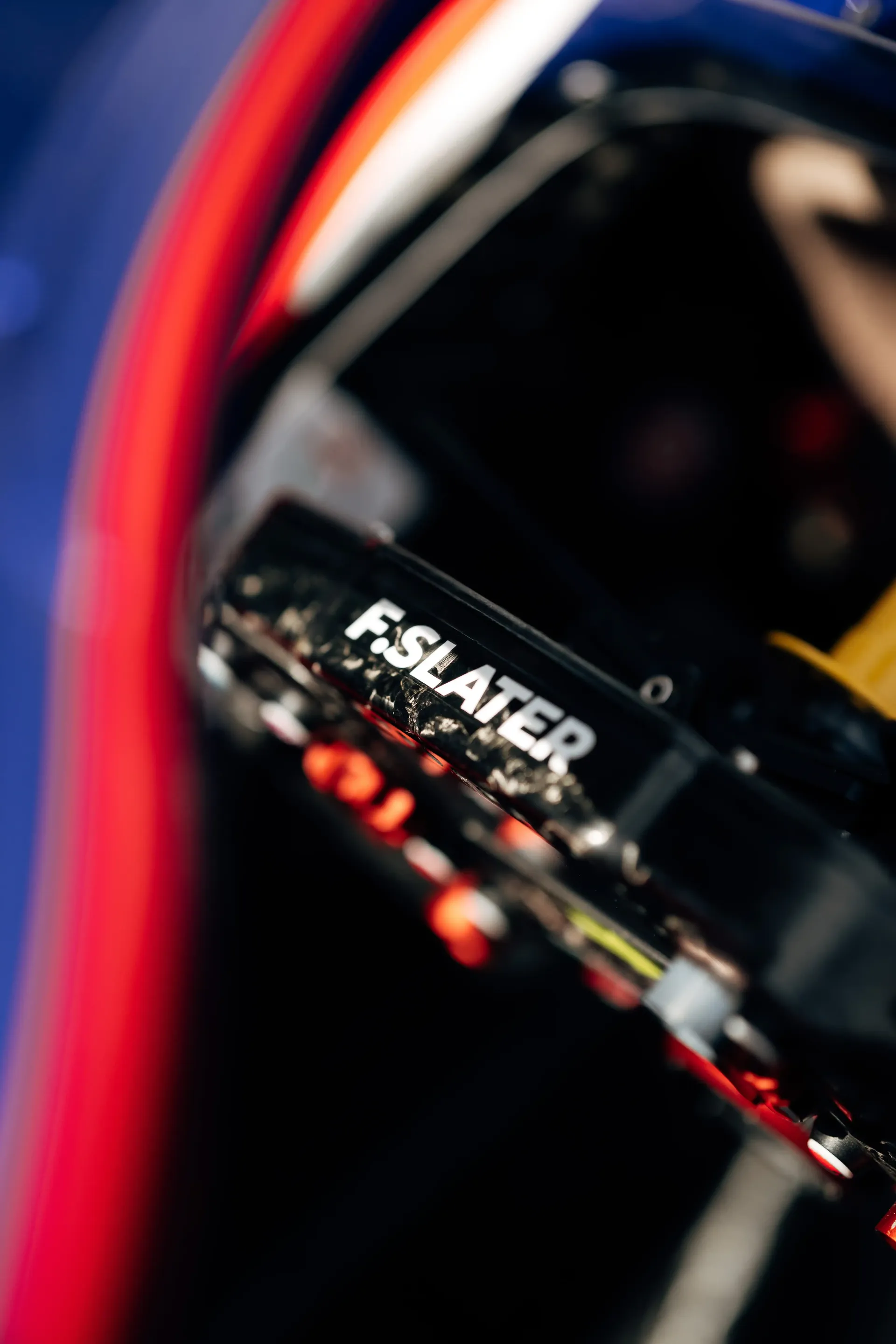 Close-up detail of Freddie Slater's helmet and cockpit area inside his FIA Formula 3 car, highlighting Audi-backed driver branding and race equipment.