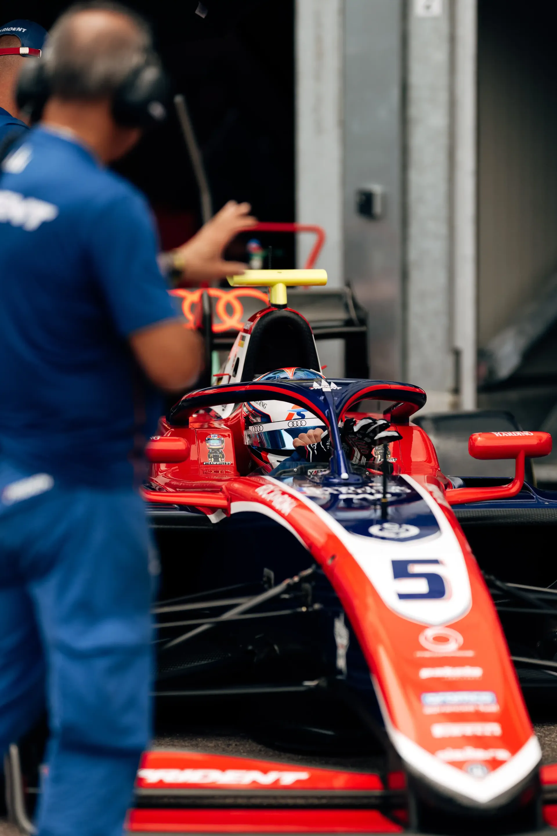 A mechanic prepares Freddie Slater's number 5 FIA Formula 3 car inside the Monaco paddock garage before a session.