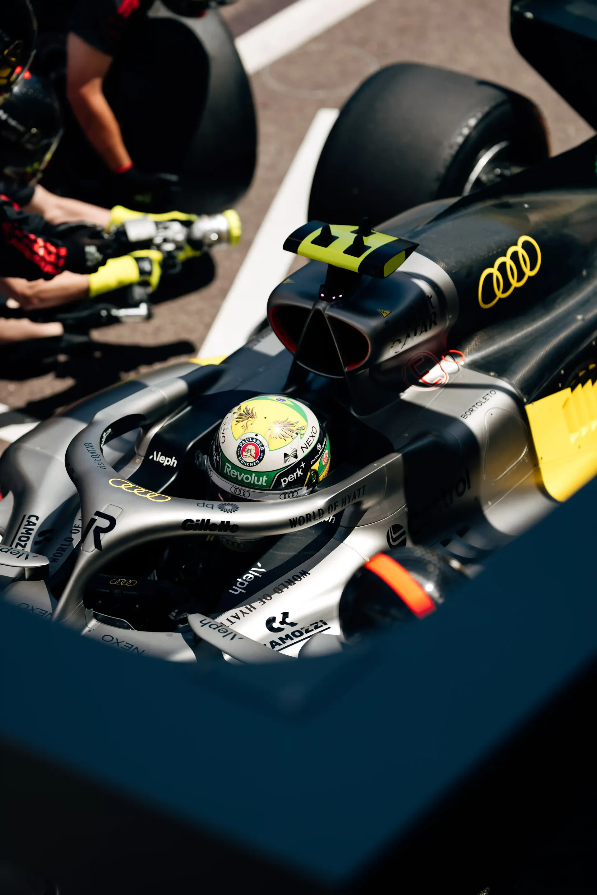 Close-up of the Audi Revolut F1® Team F1® car cockpit with the driver seated as the crew prepares for practice.