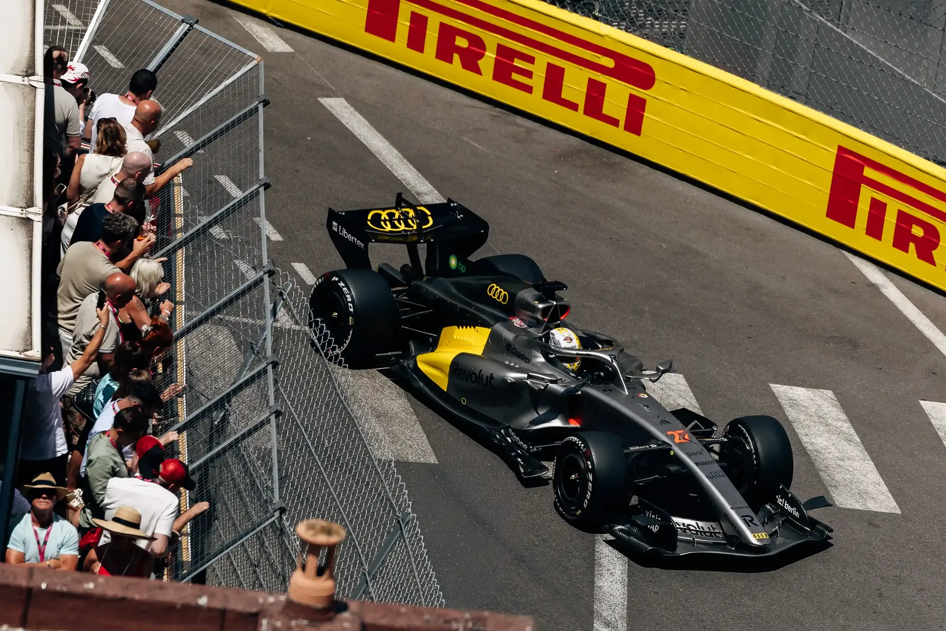 Audi Revolut F1® Team car R26  on track during Monaco Grand Prix FP1, passing spectators and barriers on the Monaco street circuit.
