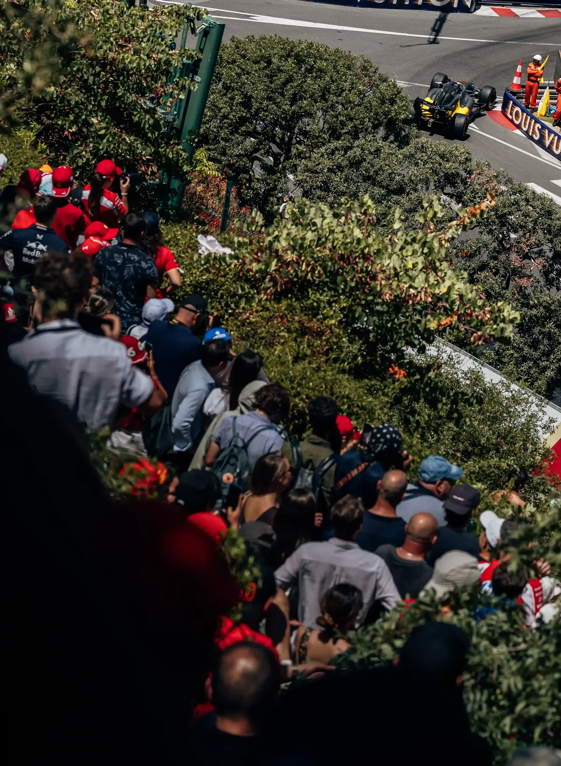 Spectators watch from a hillside vantage point overlooking the Monaco circuit during FP3.