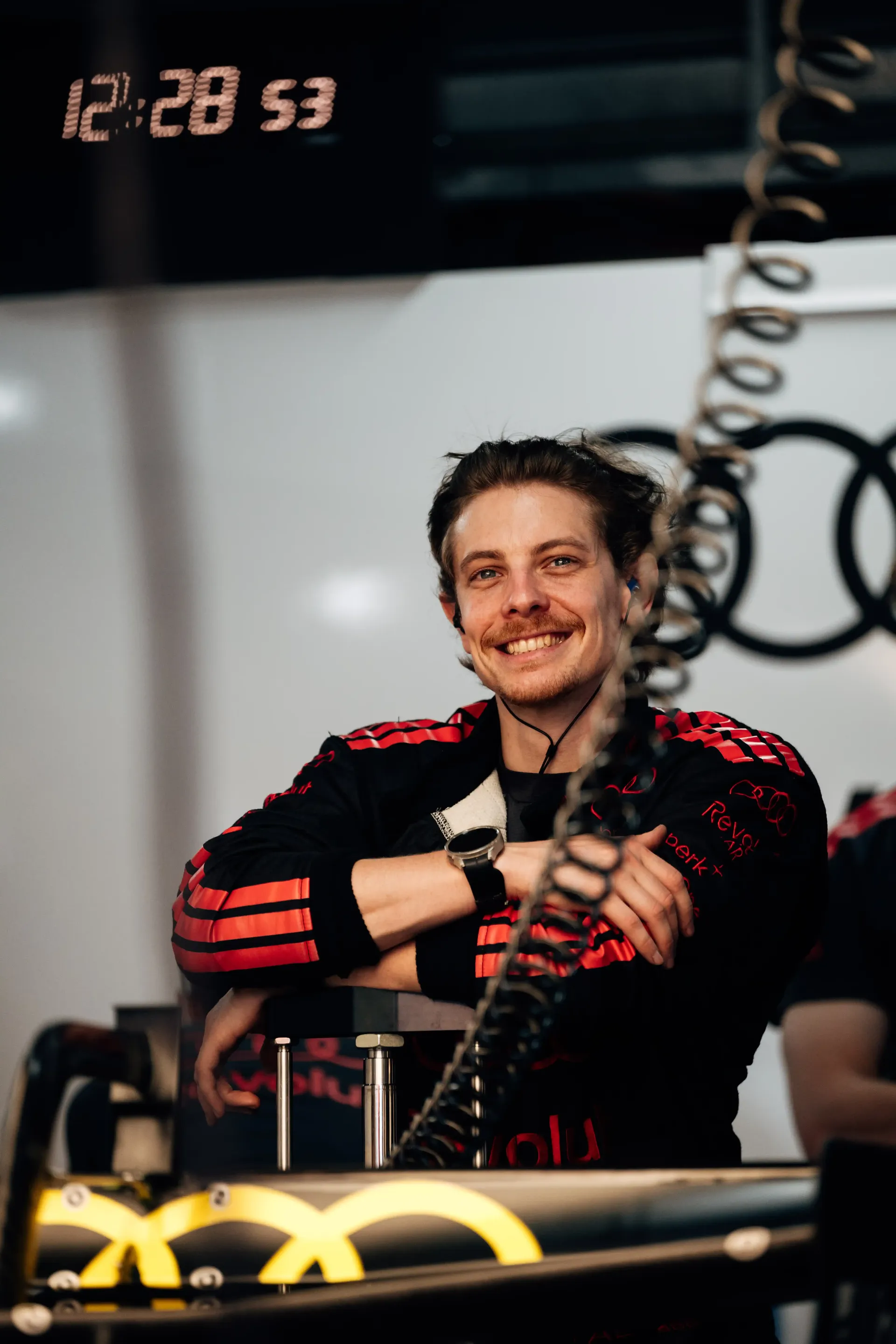 Audi Revolut F1® Team crew mechanic smiles while standing in the garage during FP3 preparations.