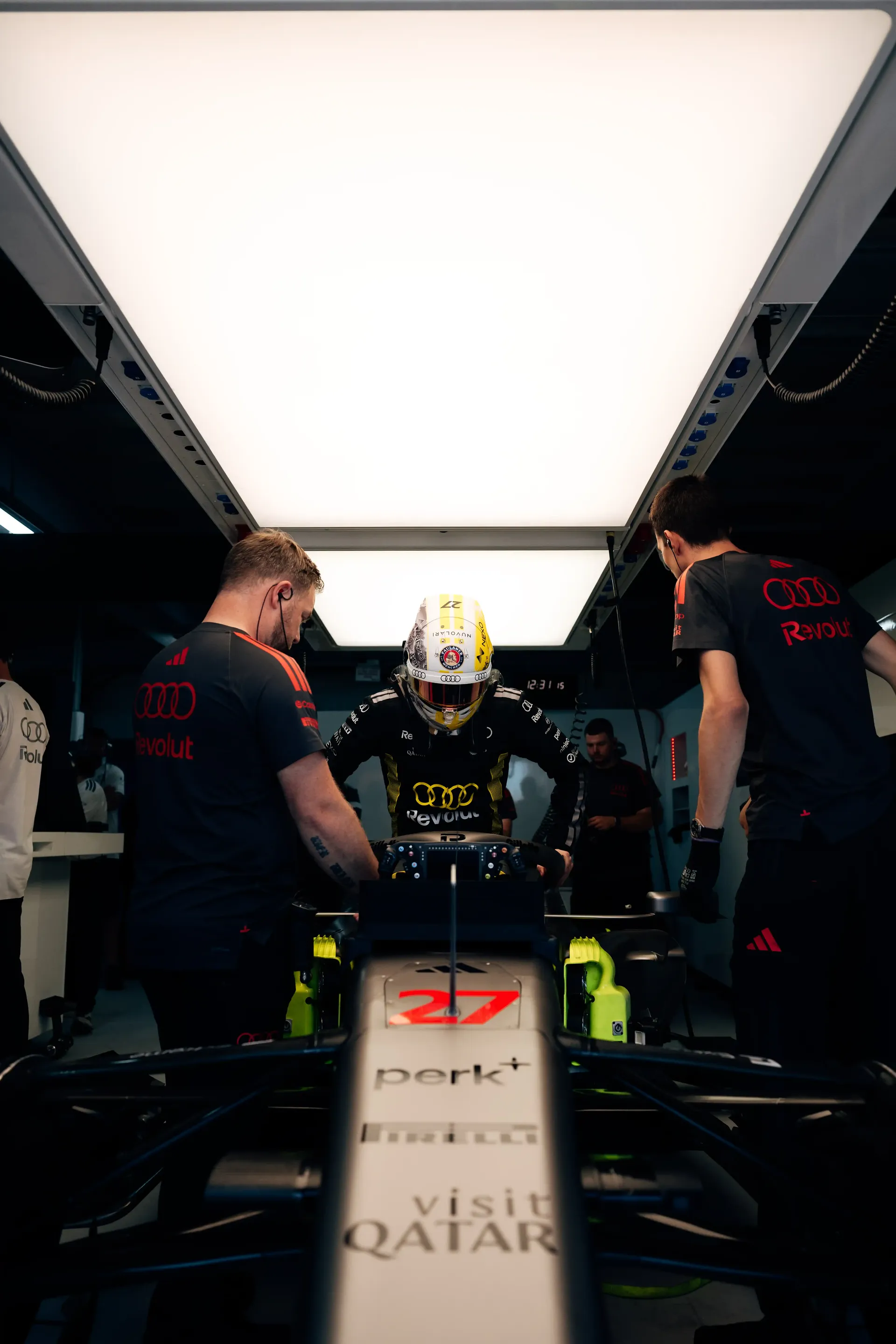 Rear view of the Audi Revolut F1® Team Formula 1 car R26 inside the garage as crew members prepare the car.
