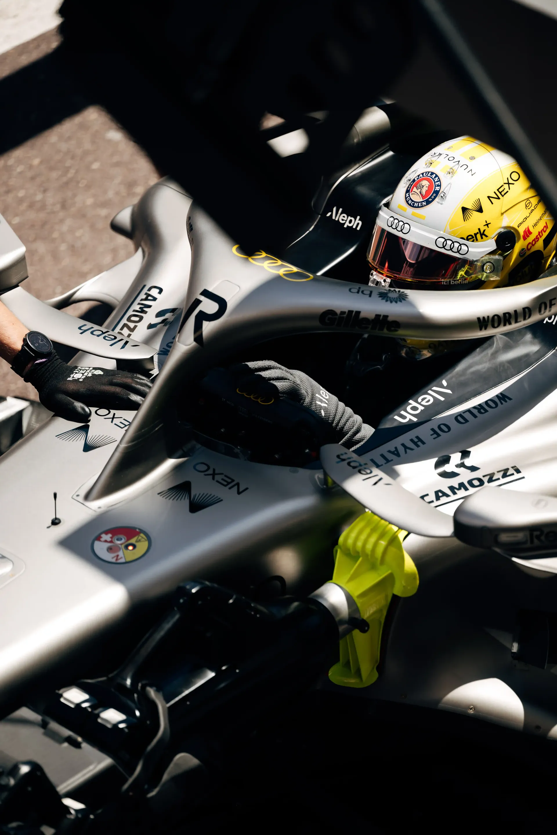 Nico Hulkenberg sits in the cockpit of the Audi Revolut F1® Team Formula 1 car R26 viewed from above during garage preparations.