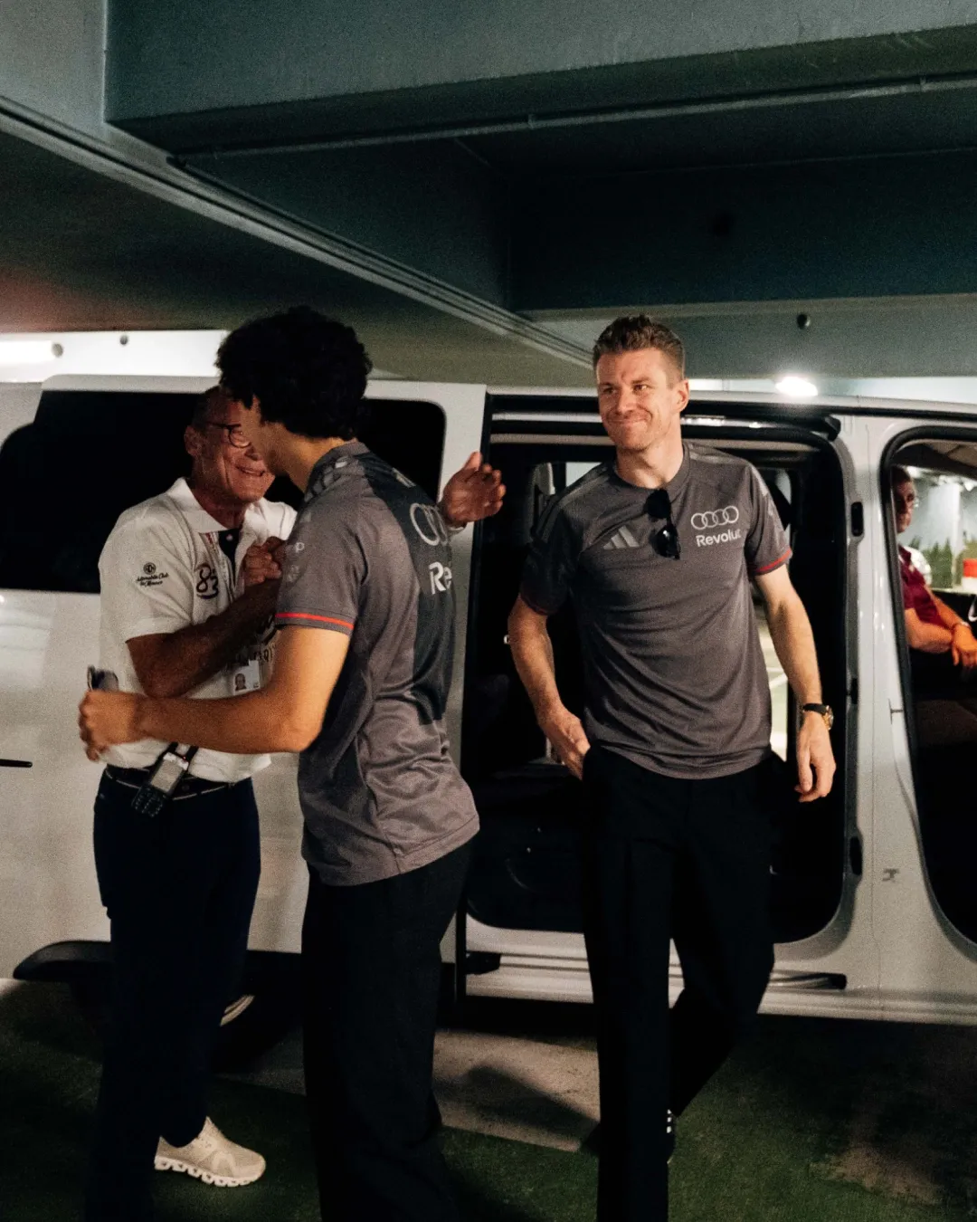 Gabriel Bortoleto and Nico Hülkenberg speak with team personnel backstage following an Audi Revolut F1® Team fan engagement event in Monaco.