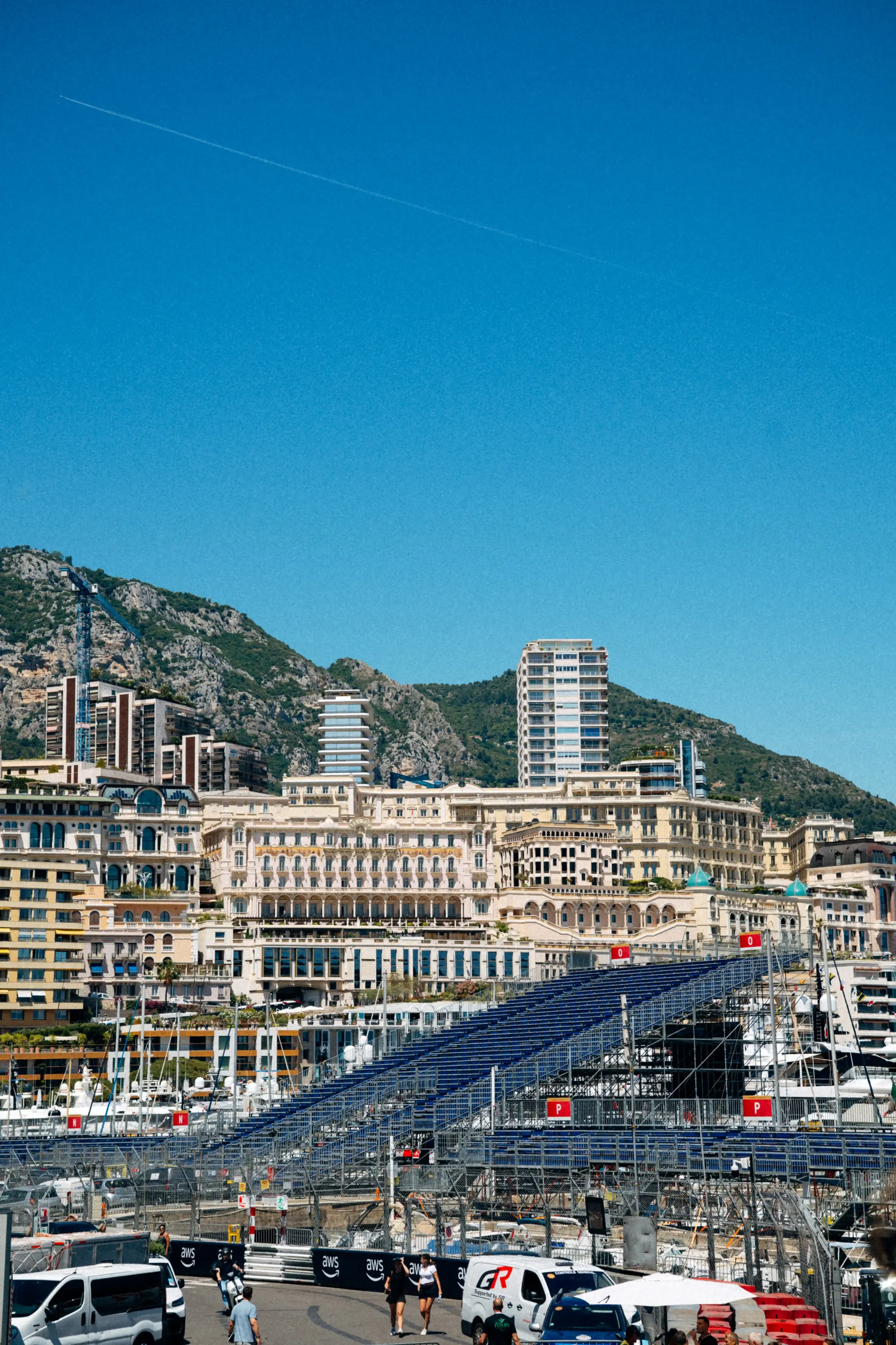 Monaco waterfront skyline with marina, luxury buildings, and hillside backdrop.