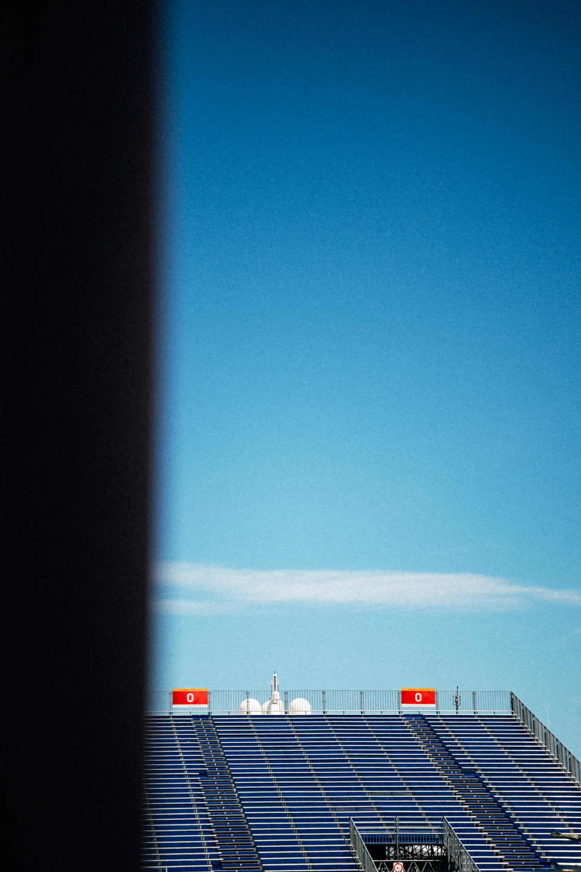 Minimalist view of a yacht deck extending toward a bright blue sea and sky horizon.