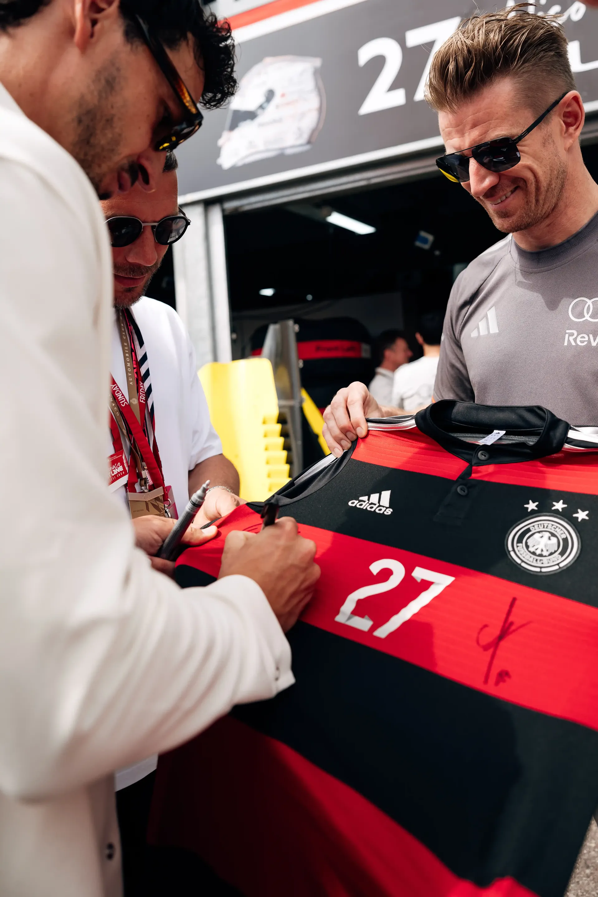 Nico Hulkenberg, Audi Revolut F1® Team driver, signs a football jersey during a shirt swap event in the Monaco paddock.