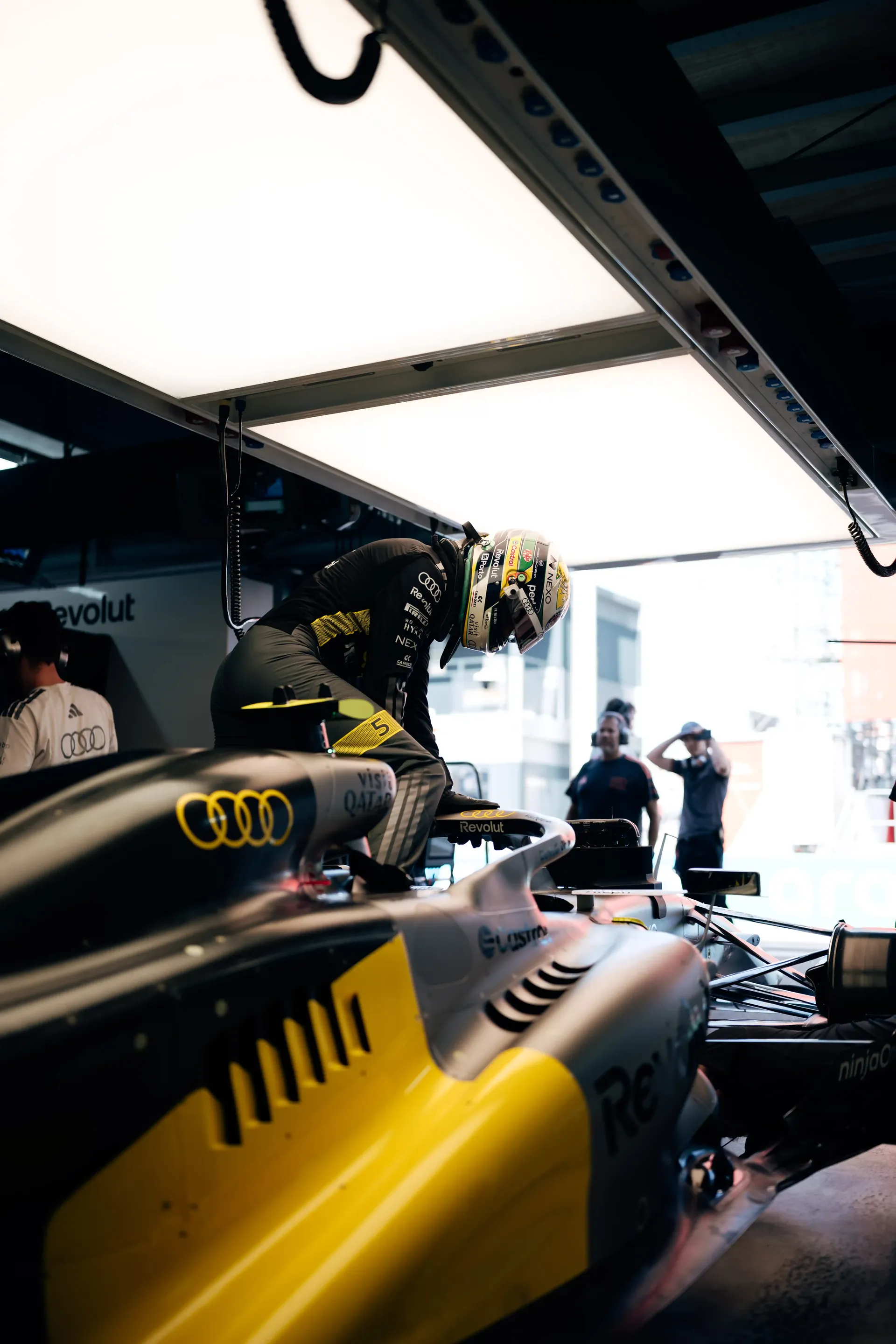 Detail view of the Audi Revolut F1® Team race car R26 in the garage with the driver preparing to head out.