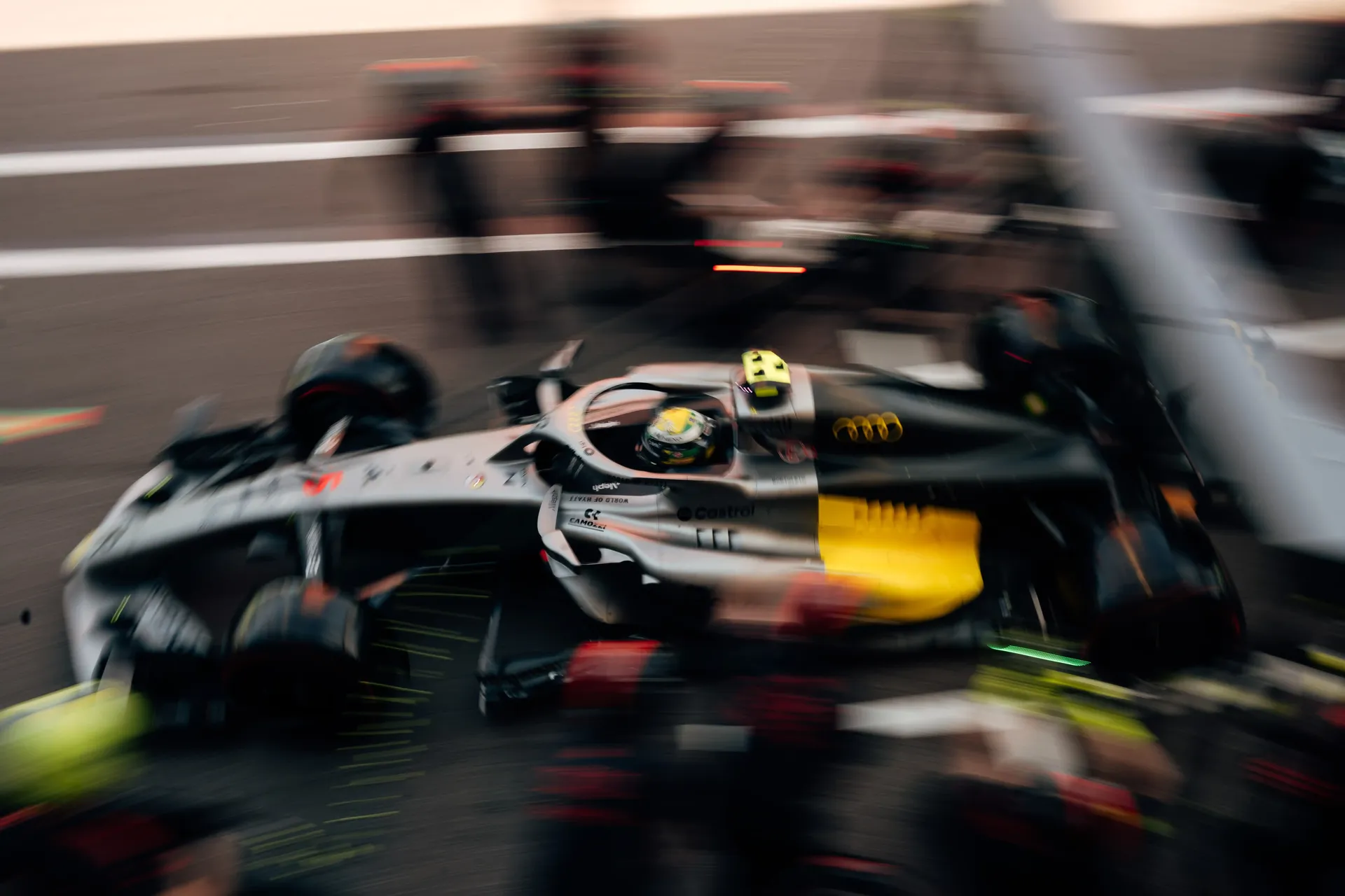 Audi Revolut F1® Team race car exits the pit lane in a dynamic motion-blur shot during qualifying.