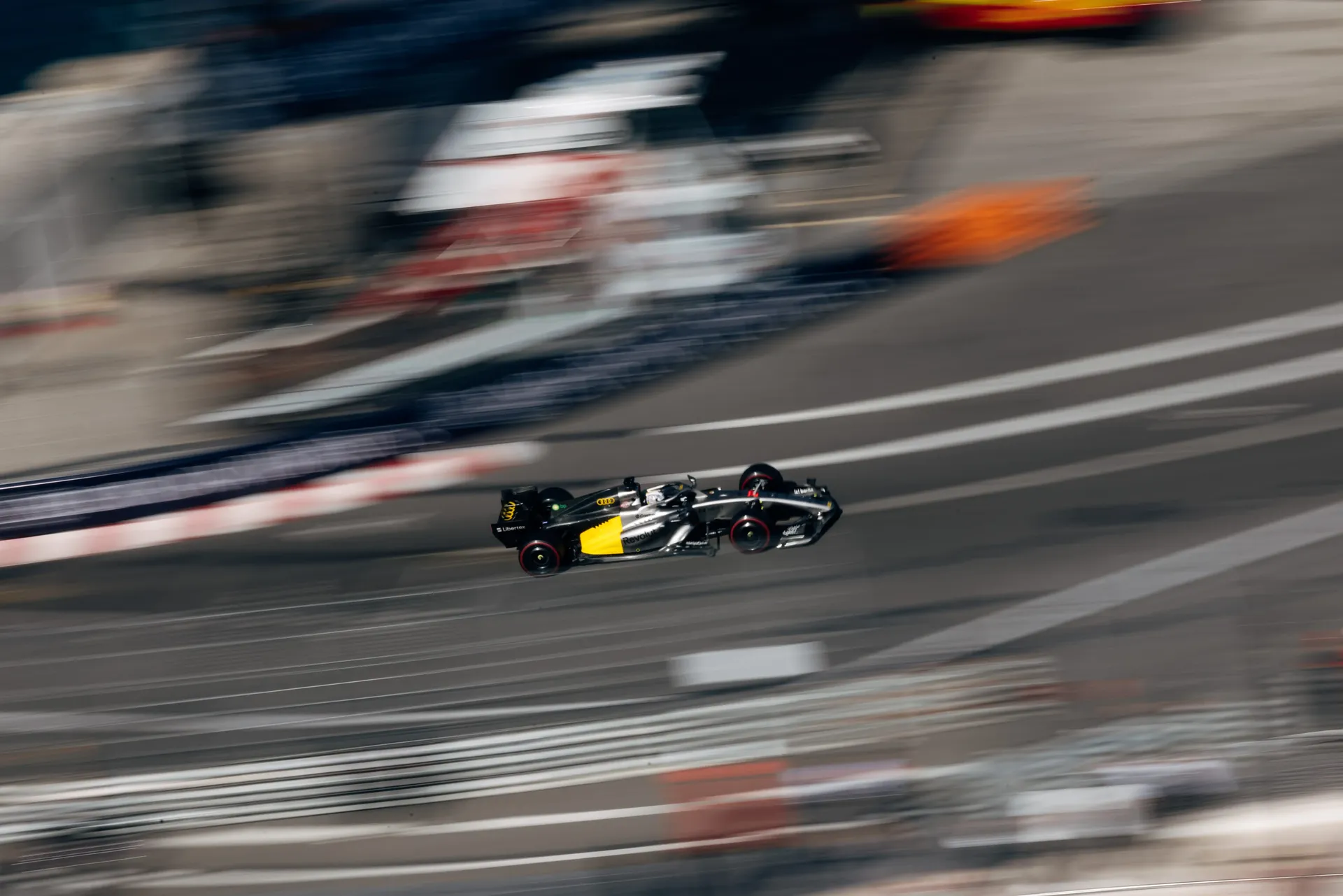Audi Revolut F1® Team race car navigates a Monaco street circuit corner in a high-speed aerial shot during qualifying.
