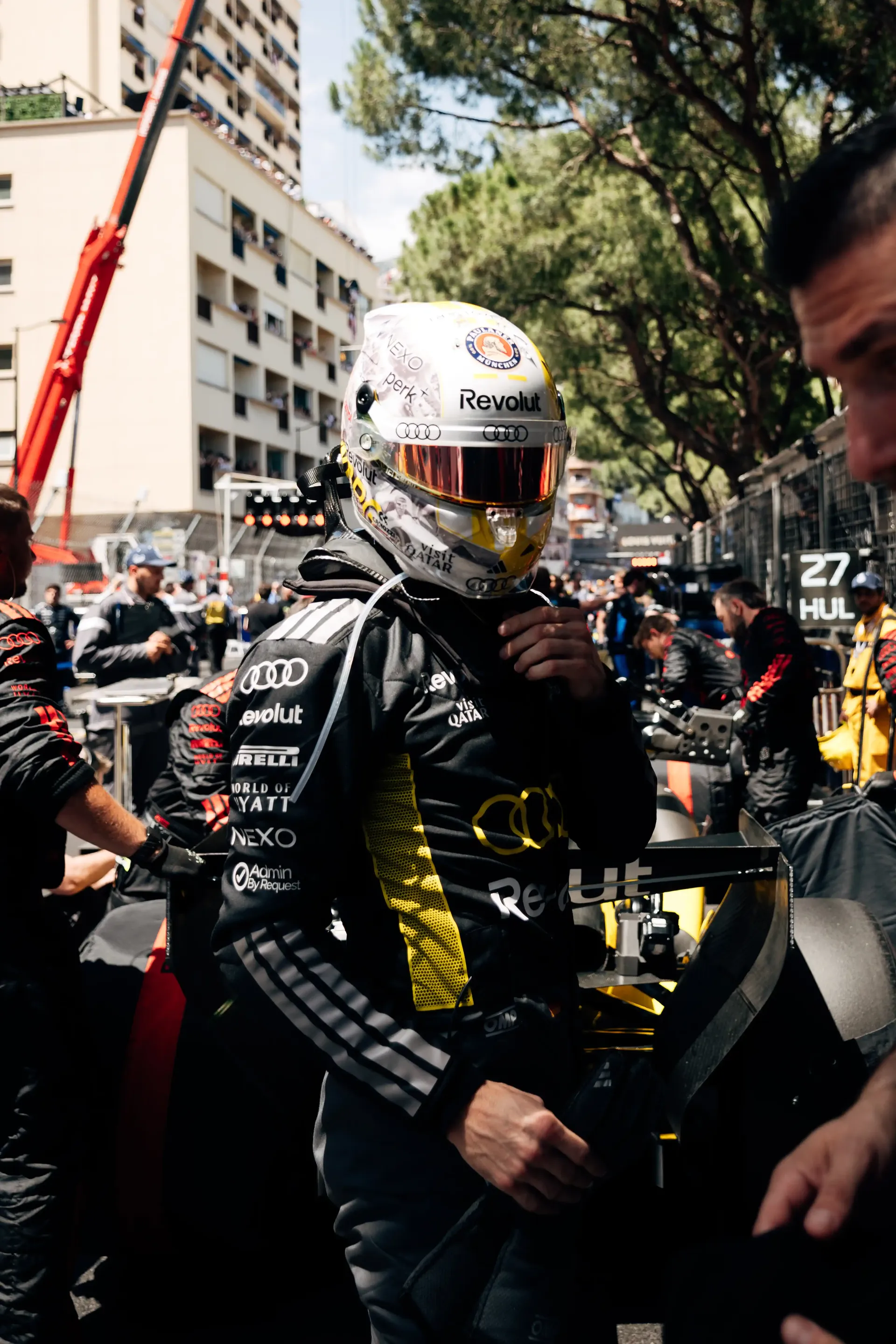 Audi Revolut F1® Team driver Nico Hulkenberg walks through the Monaco Grand Prix grid wearing a race helmet before the start.