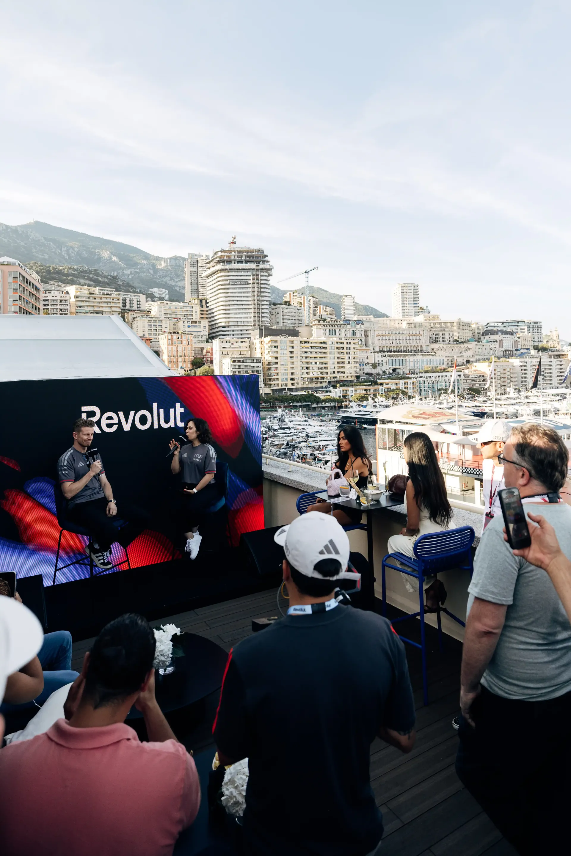 Guests watch Nico Hulkenberg during a live appearance at the Revolut Apartment overlooking Monaco.