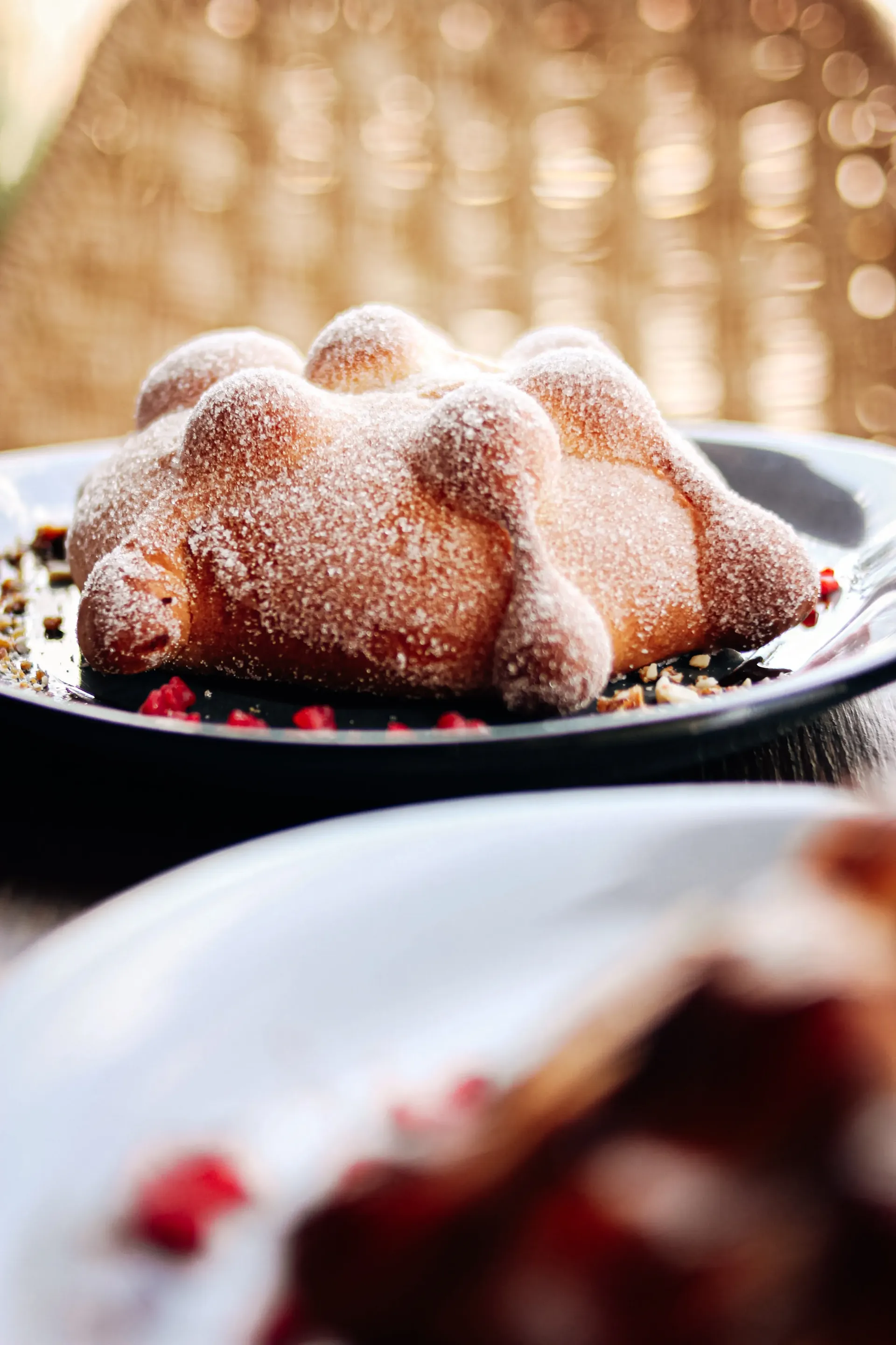 Close-up of sugar-coated pan de muerto, the bread of the dead, on a dark plate