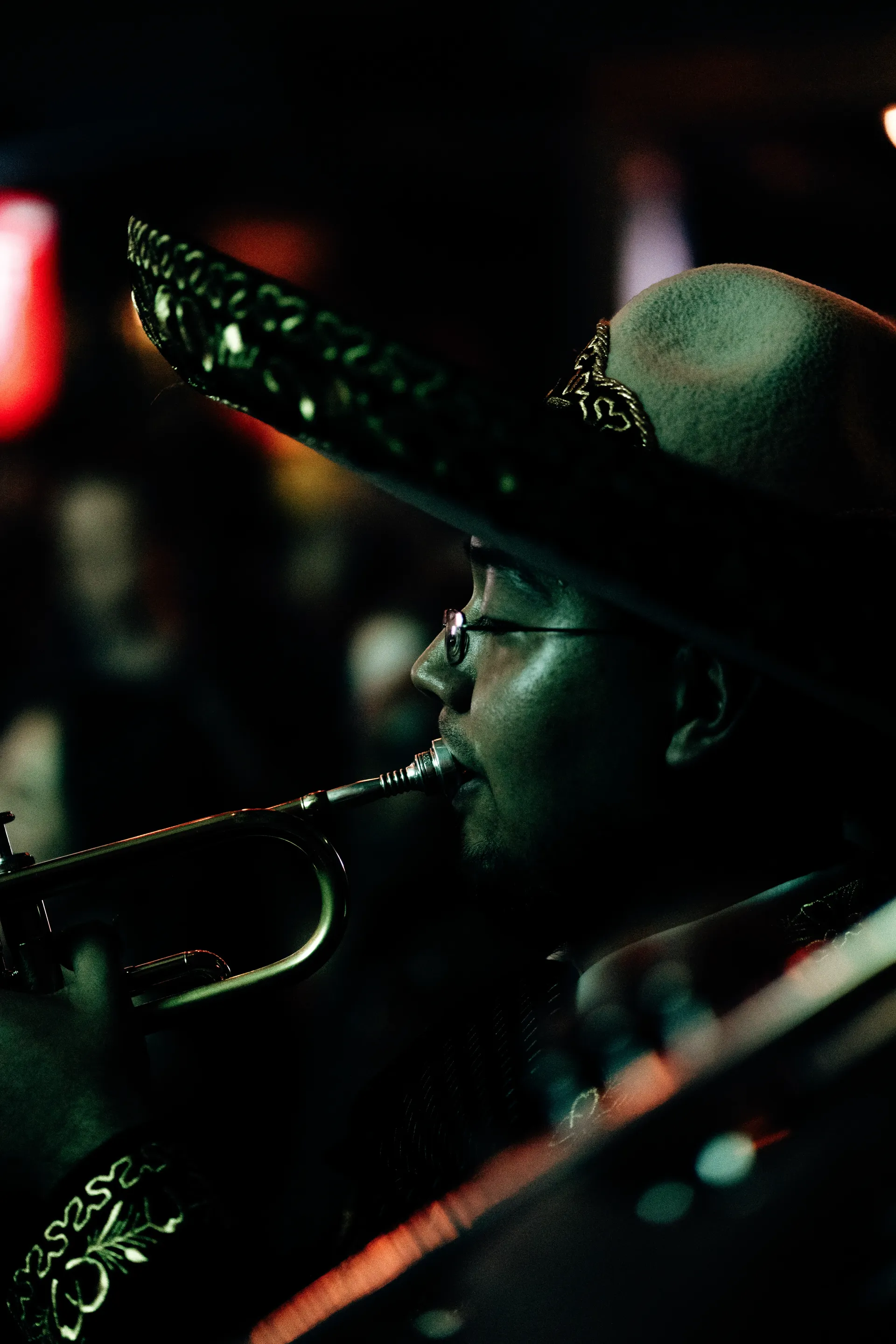 Mariachi musician in an embroidered sombrero playing the trumpet at night in Mexico City