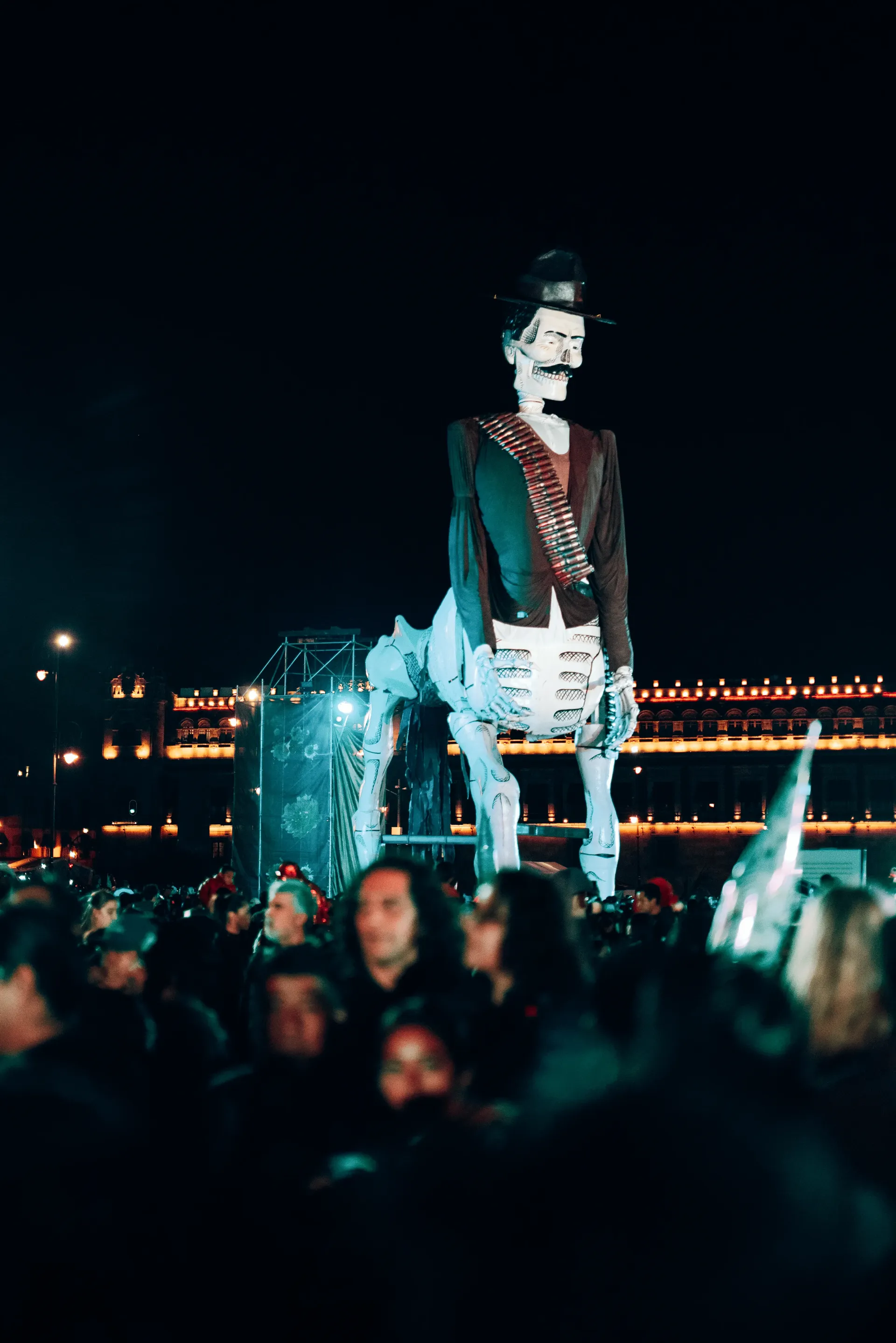 Giant skeleton figure in a hat and bandolier above the crowd during Día de los Muertos in Mexico City