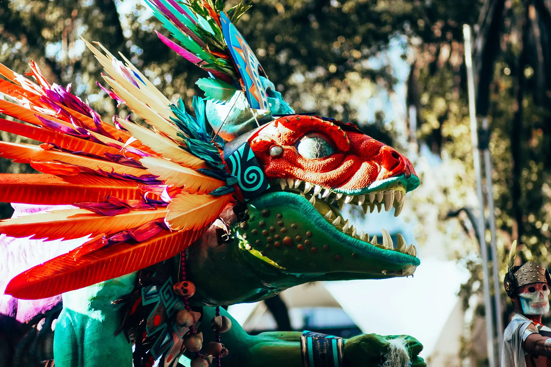 Close-up of a feathered alebrije with a red dragon-like head at the Día de los Muertos parade in Mexico City