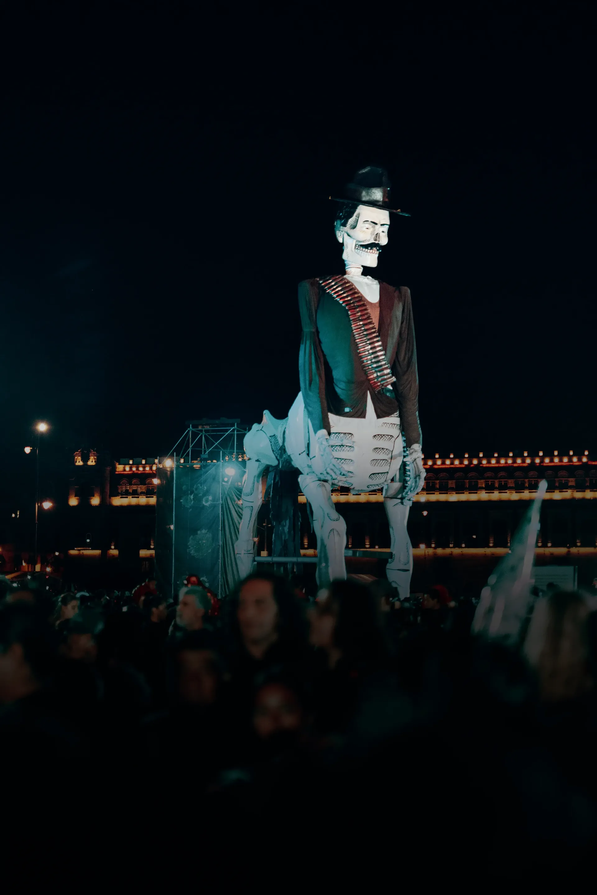 Giant skeleton figure in a hat and bandolier above the crowd during Día de los Muertos in Mexico City