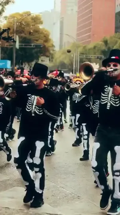 Musicians dressed in black playing trumpets at the Día de los Muertos parade in Mexico City
