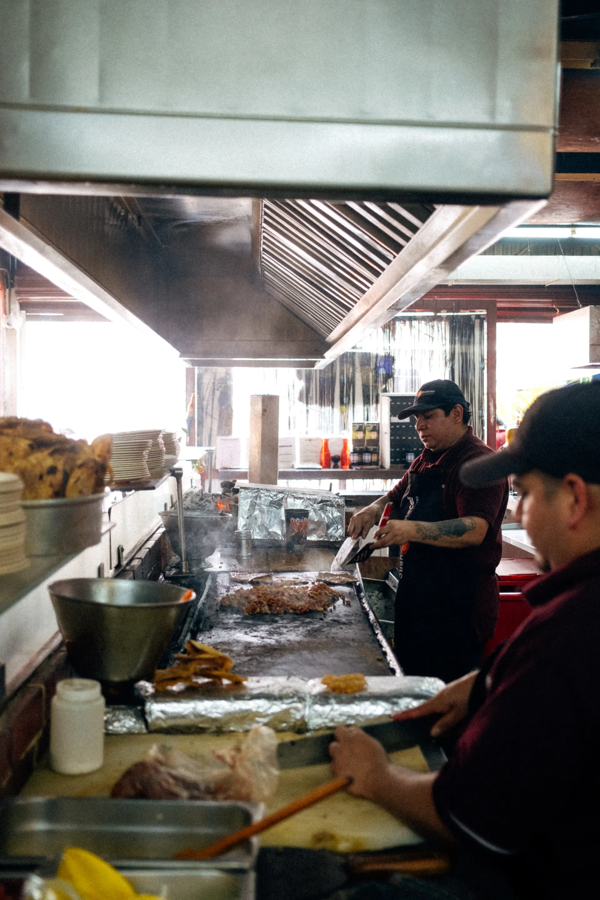 Cooks preparing tacos on a flat-top grill at a taqueria during the Mexico City Grand Prix week