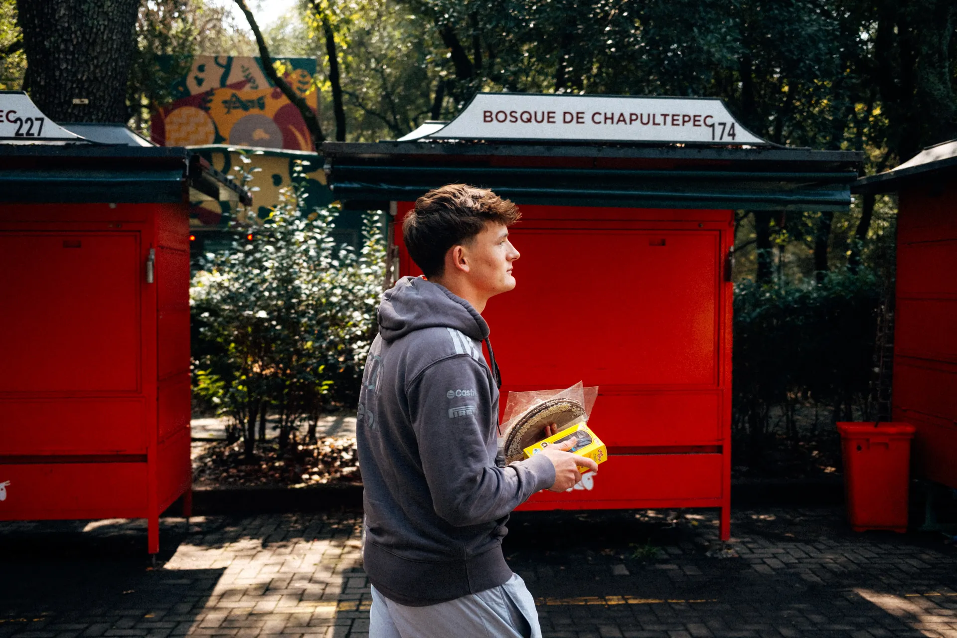Freddie Slater of the Audi Driver Development Programme carrying snacks past kiosks in Bosque de Chapultepec