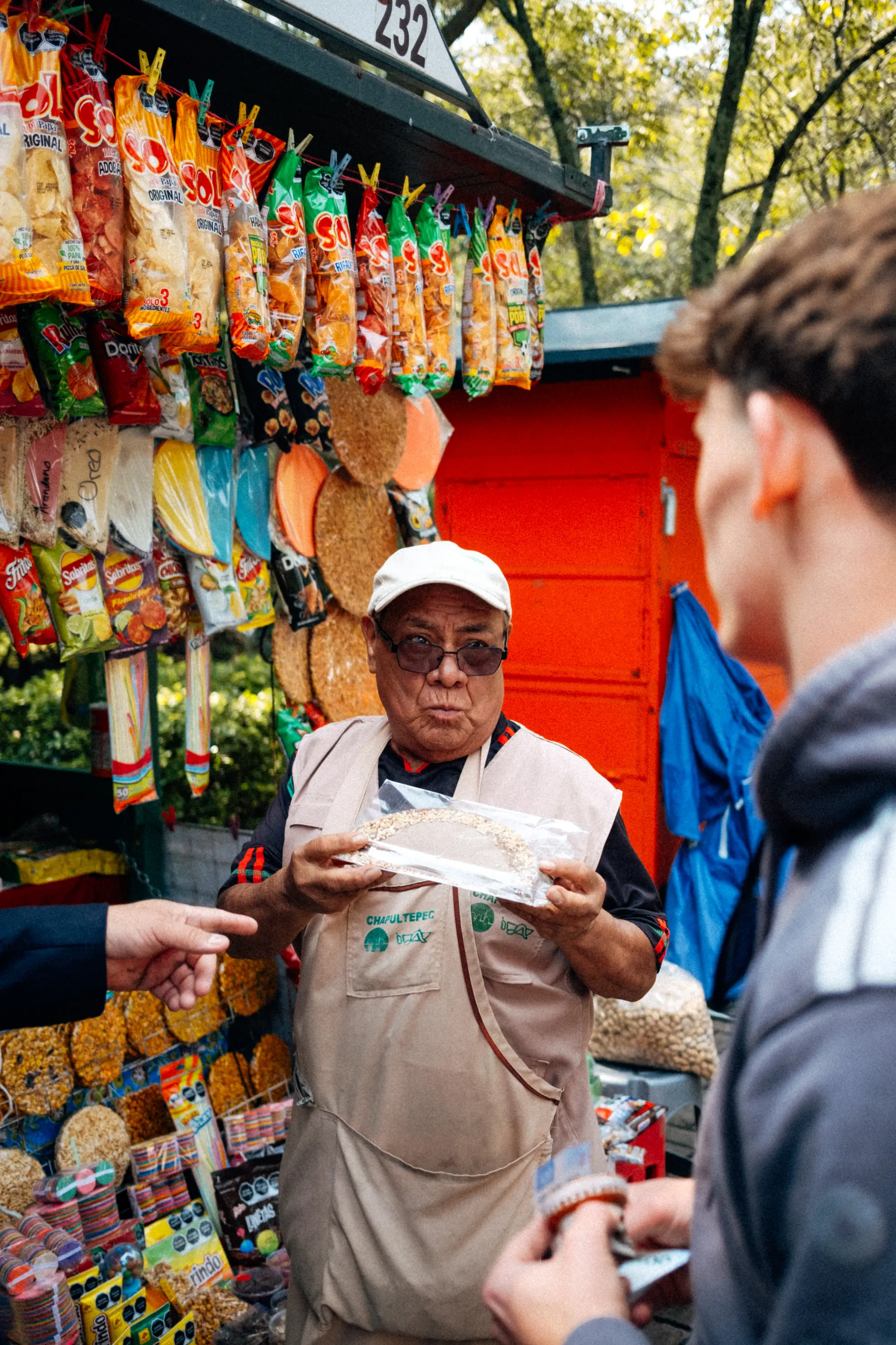 Freddie Slater buying a snack from a vendor at a kiosk in Bosque de Chapultepec, Mexico City