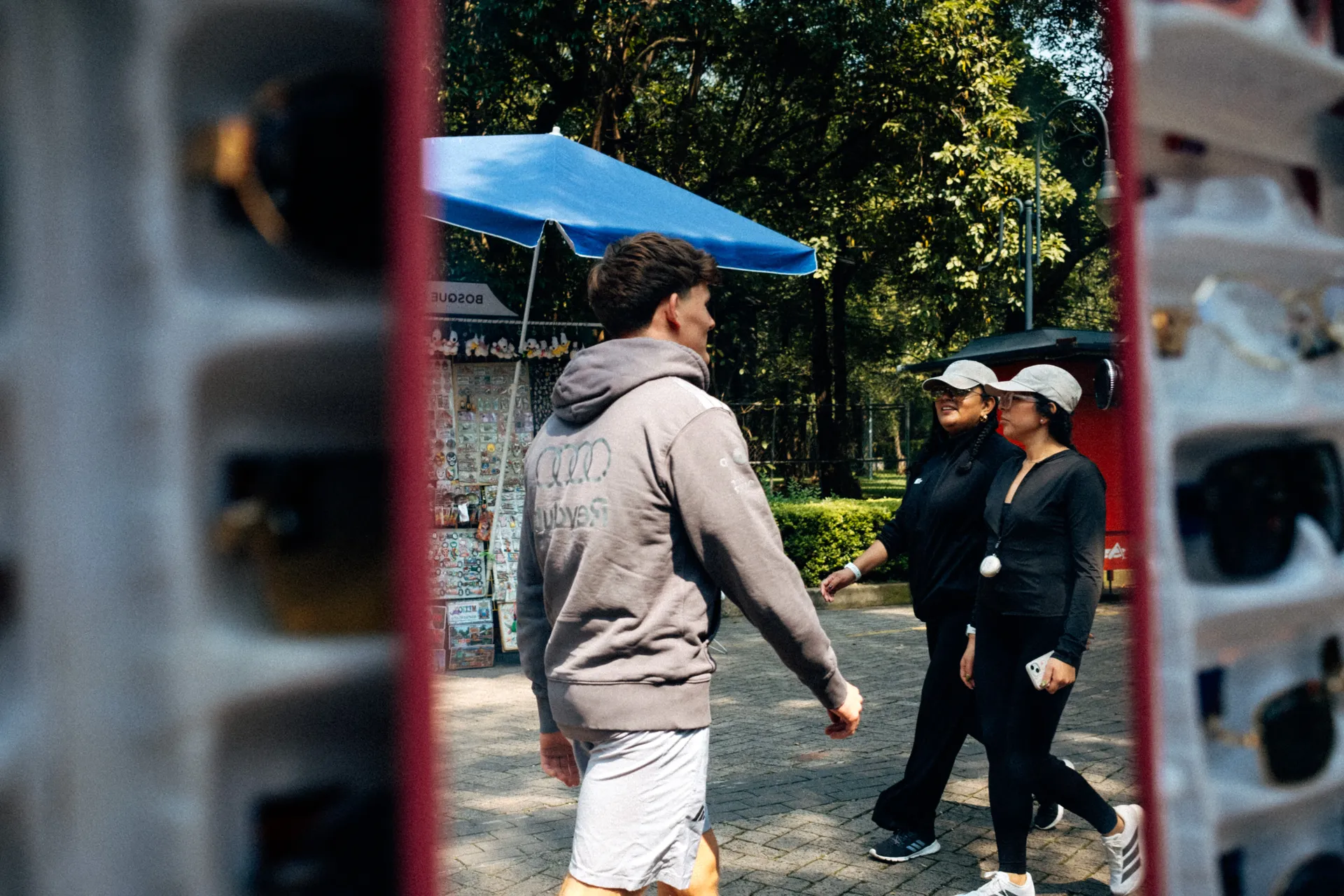 Freddie Slater in an Audi Revolut F1® Team hoodie walking past souvenir stalls in Bosque de Chapultepec, Mexico City