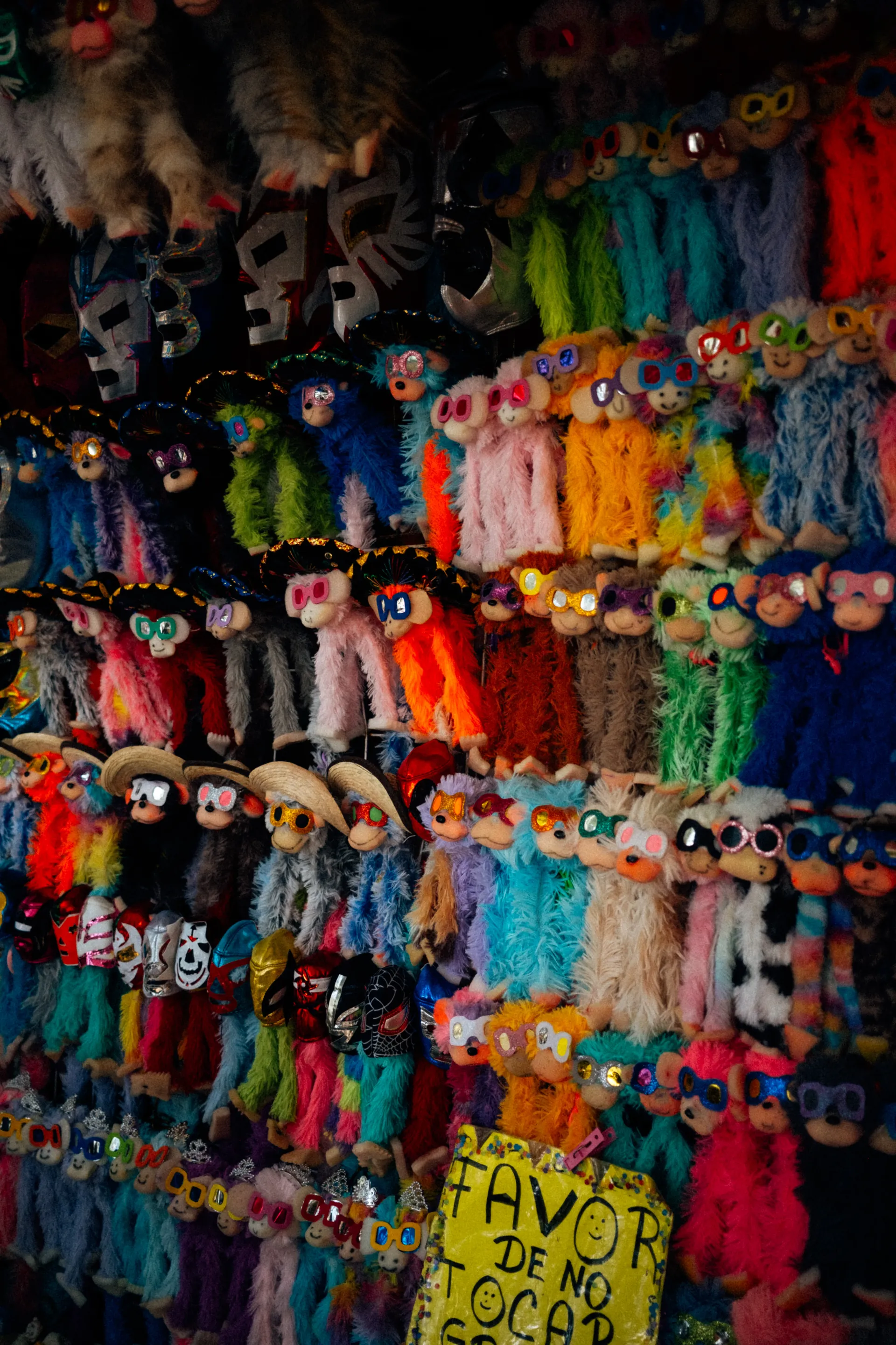 Colourful plush monkeys with sunglasses and lucha libre masks at a souvenir stall in Mexico City
