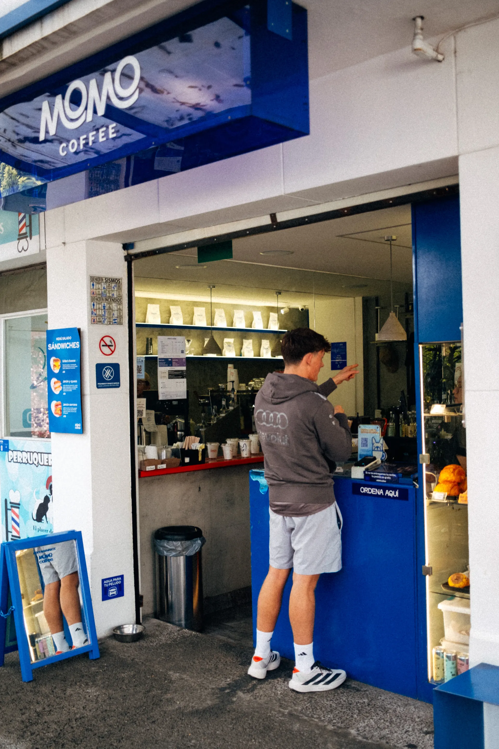 Freddie Slater in an Audi Revolut F1® Team hoodie ordering at the counter of Momo Coffee in Mexico City