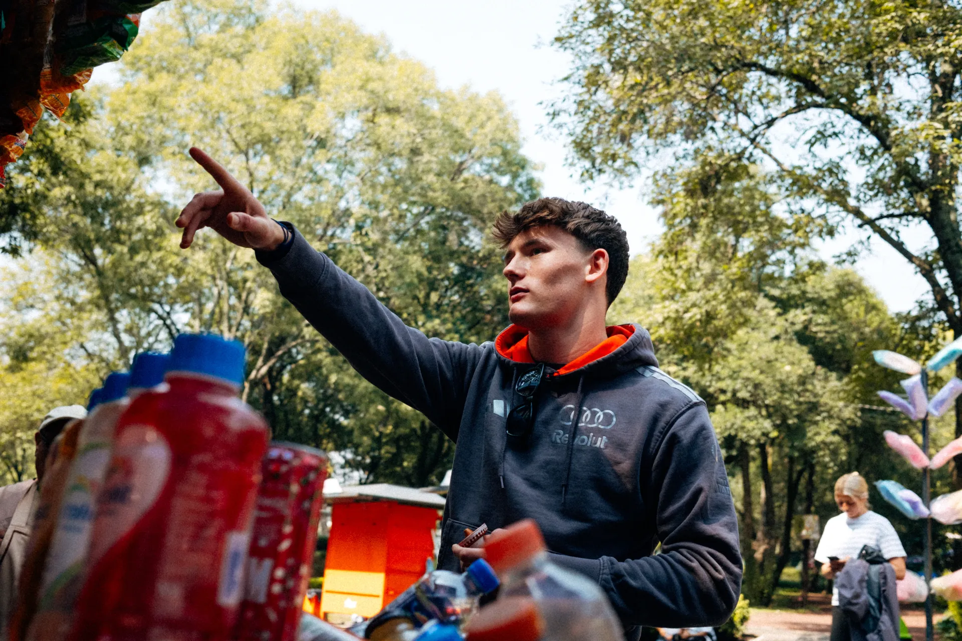 Freddie Slater in an Audi Revolut F1® Team hoodie pointing at snacks at a park kiosk in Mexico City