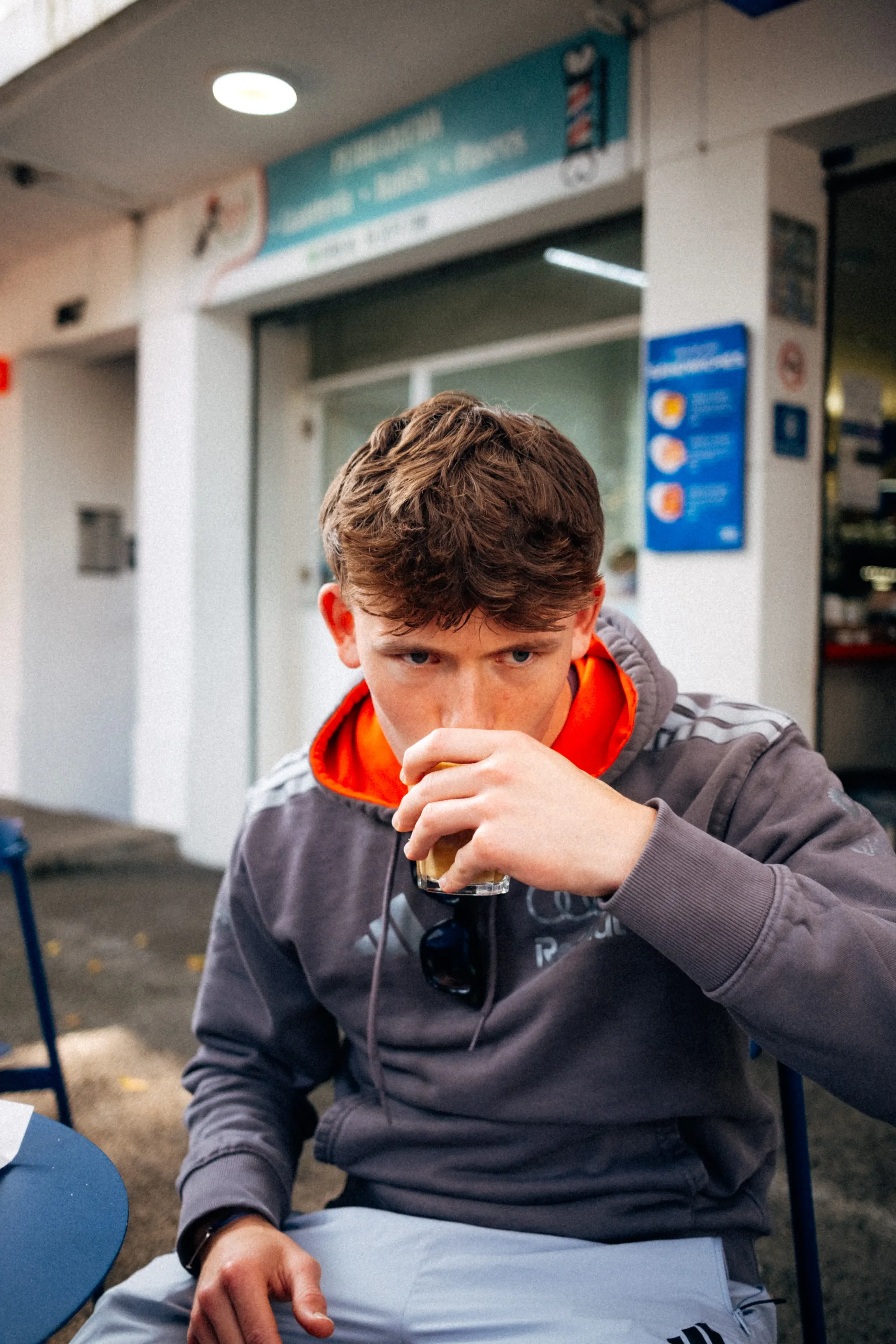 Freddie Slater in an Audi Revolut F1® Team hoodie drinking a coffee at a street cafe in Mexico City