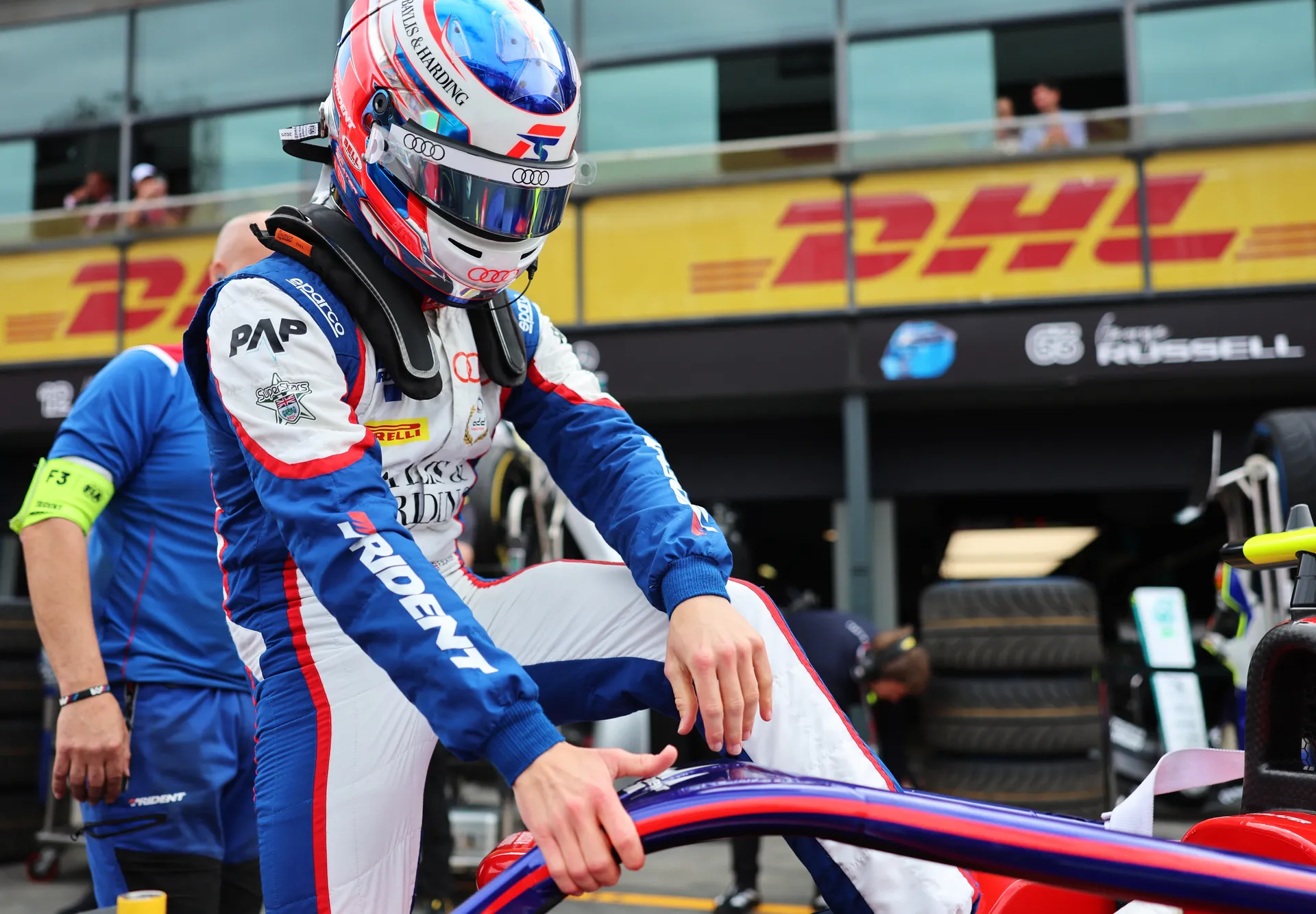 Freddie Slater wearing full helmet and race suit preparing to get into his Formula 3 car on the grid