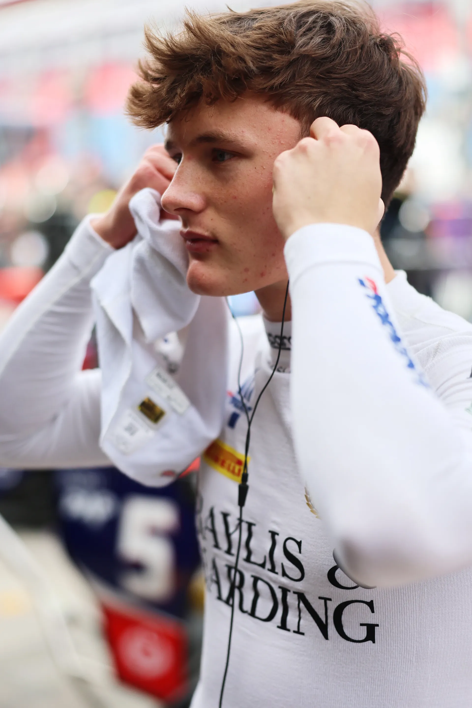Freddie Slater adjusting his in ear headphones while preparing for a Formula 3 session