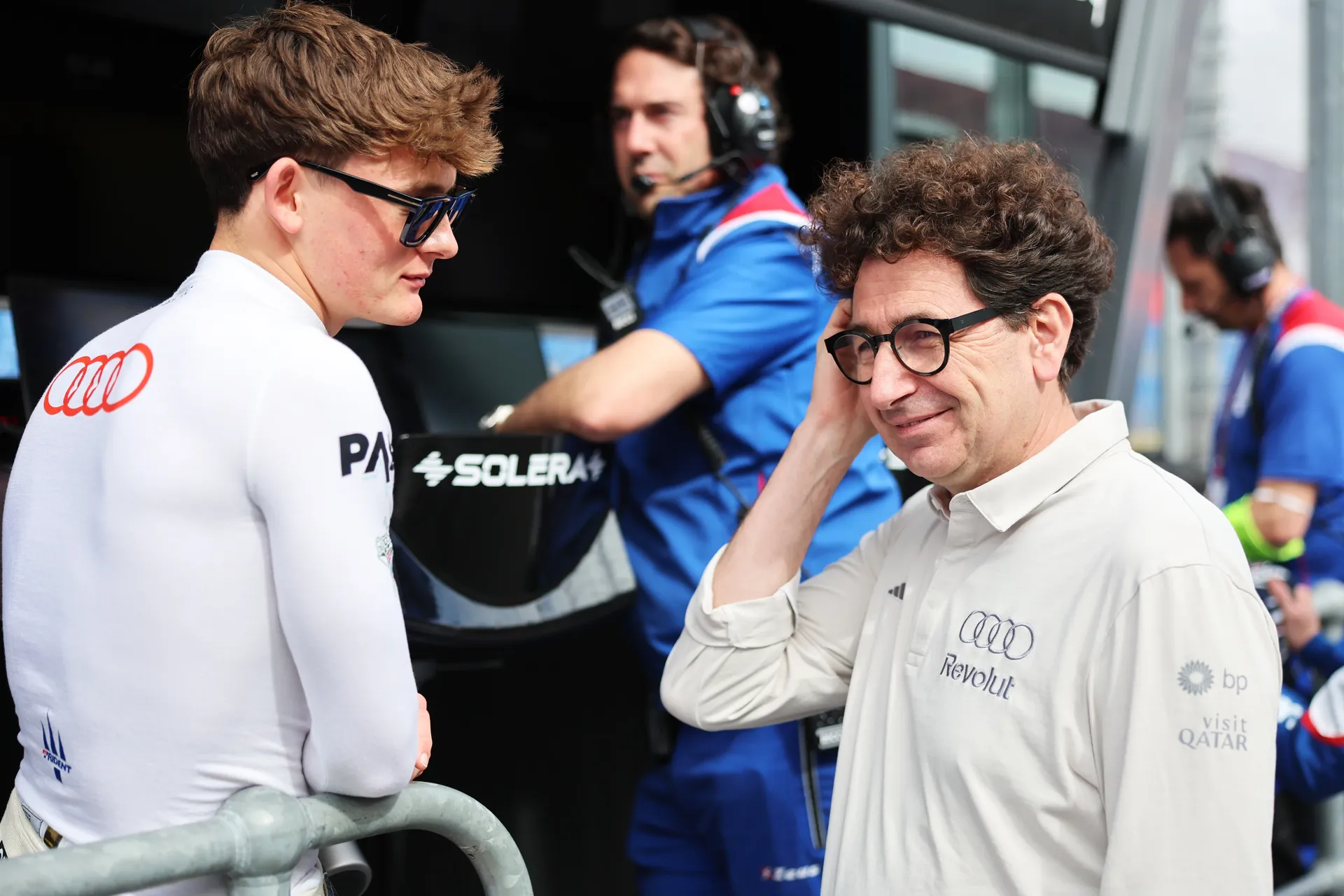 Freddie Slater speaking with Mattia Binotto while Audi Revolut F1® Team crew members work in the background during race weekend