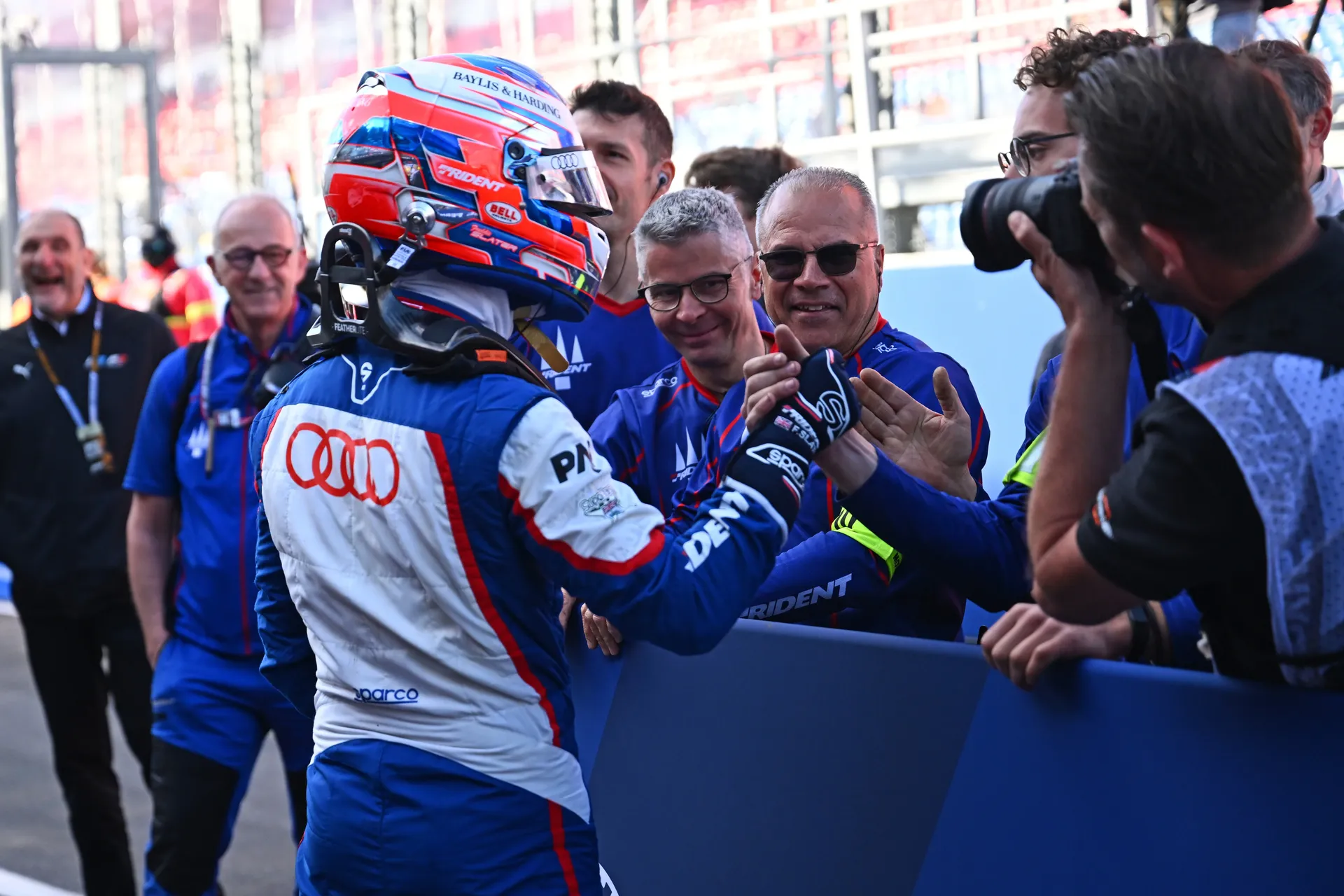 Freddie Slater wearing helmet celebrating with team members after a strong Formula 3 result