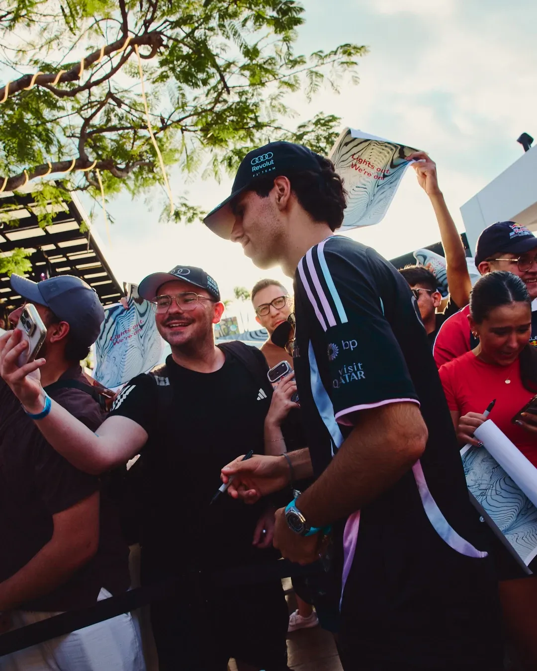 Gabriel Bortoleto signs autographs and poses with fans during the Audi Revolut F1® Team off track activation at MAPS Backlot in Miami, wearing the special adidas x Audi Revolut F1® Team Miami collection.