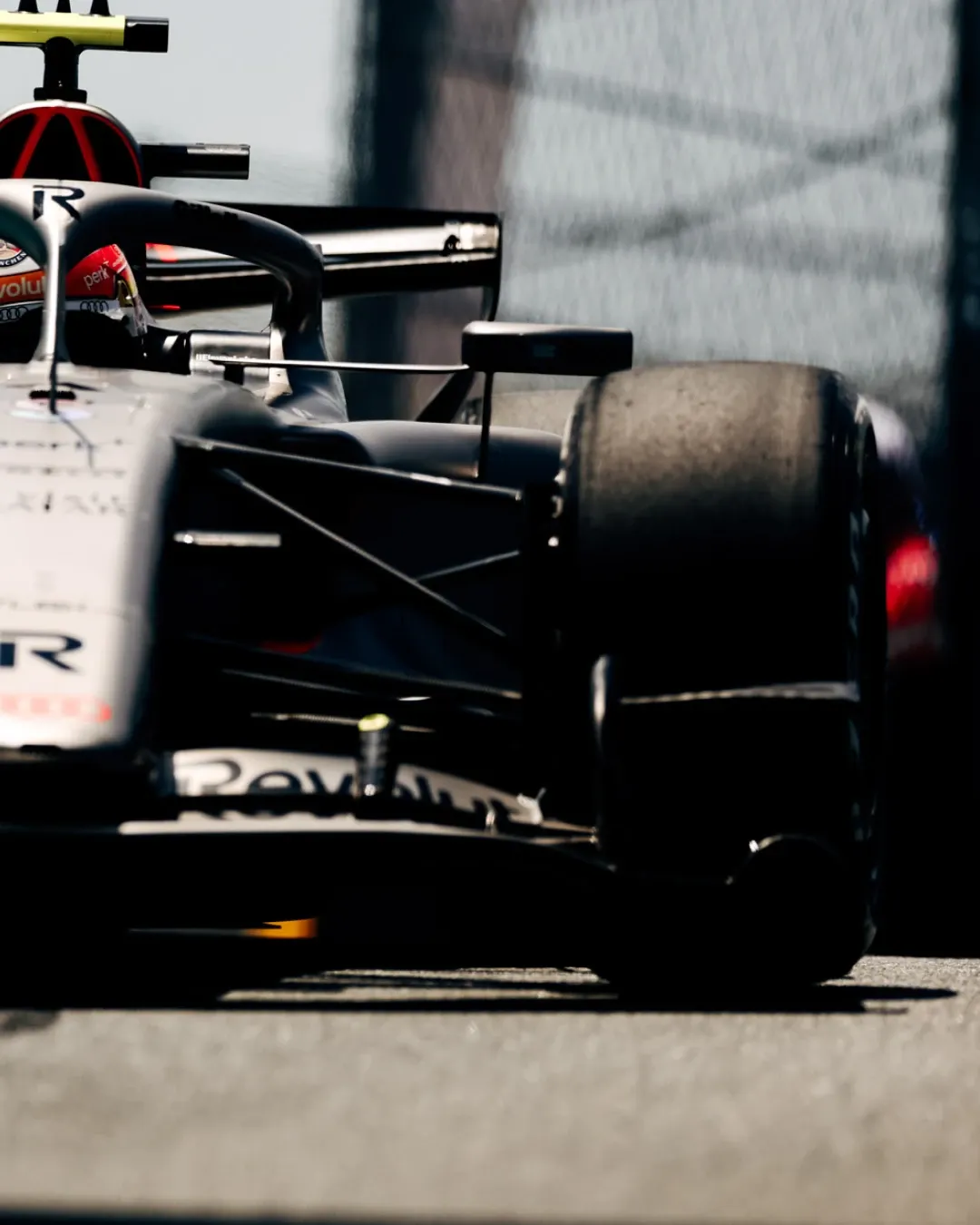 Front detail of Audi Revolut F1® Team car number 27 with Nico Hulkenberg in an orange helmet, captured low to the ground during an on track run.