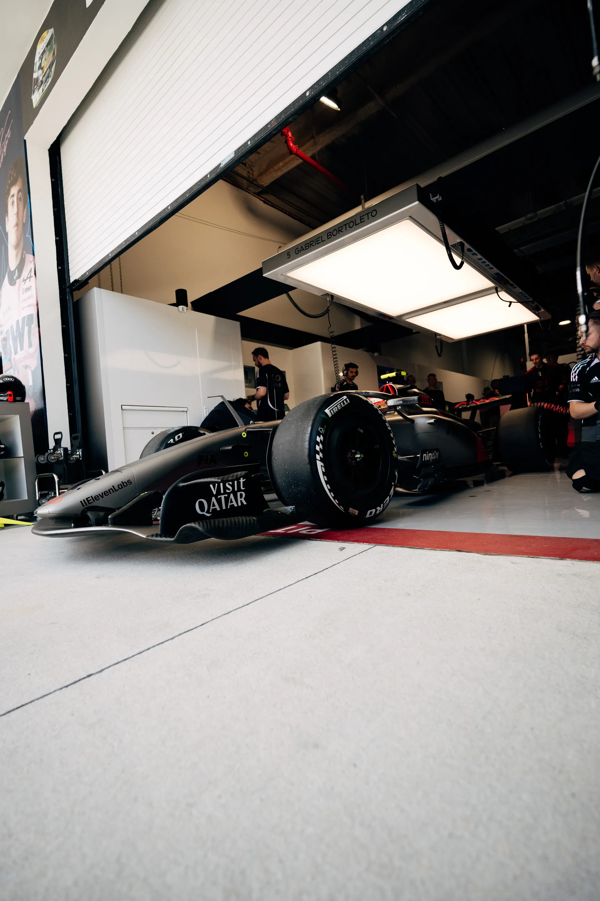 Low-angle view of Gabriel Bortoleto’s car positioned in the garage under the name board, ready for Miami track action.